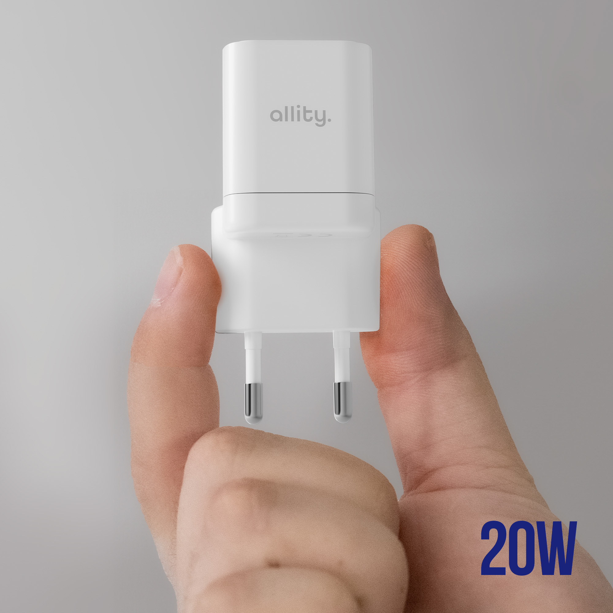 Biała ładowarka ścienna trzymana w dłoni. Ma napis 'allity.' i '20W'.