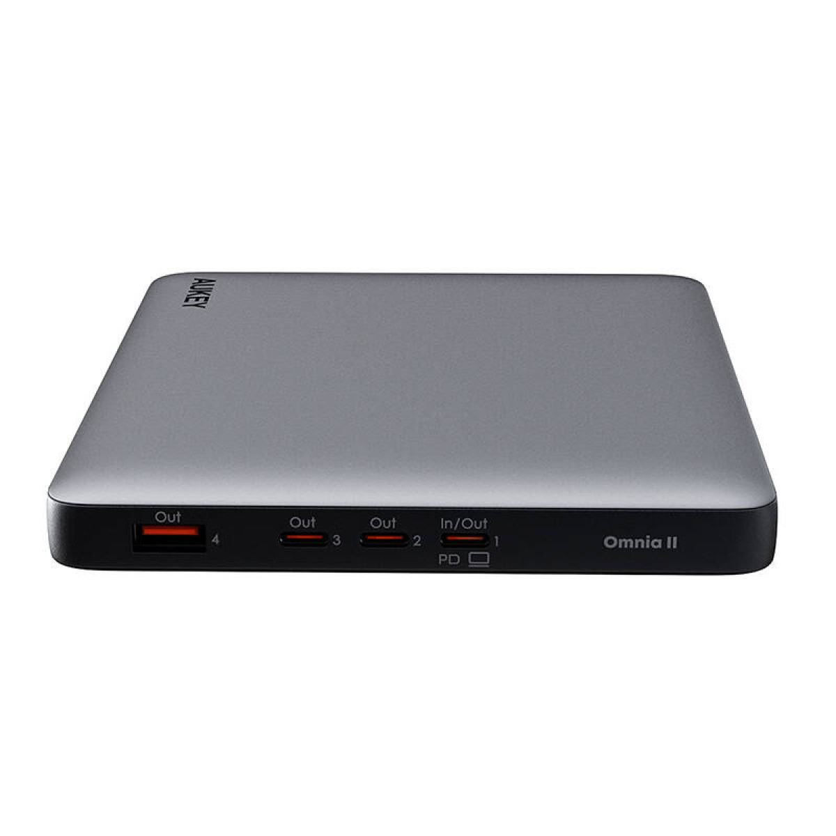Power bank grigio con marchio AUKEY. Ha più porte etichettate Out e In/Out.