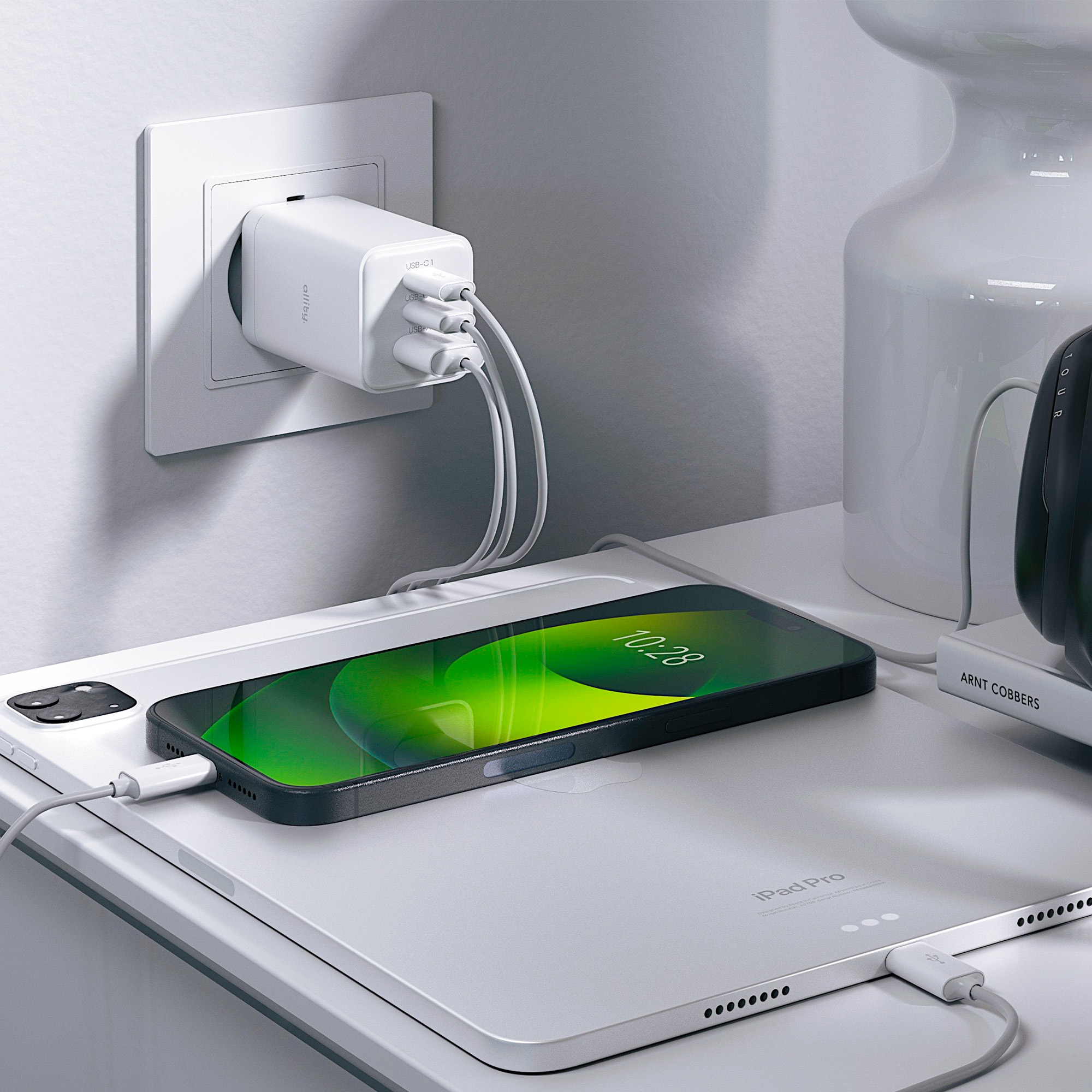 Ładowarka do telefonu w gniazdku, ładująca telefon i tablet na stoliku nocnym.