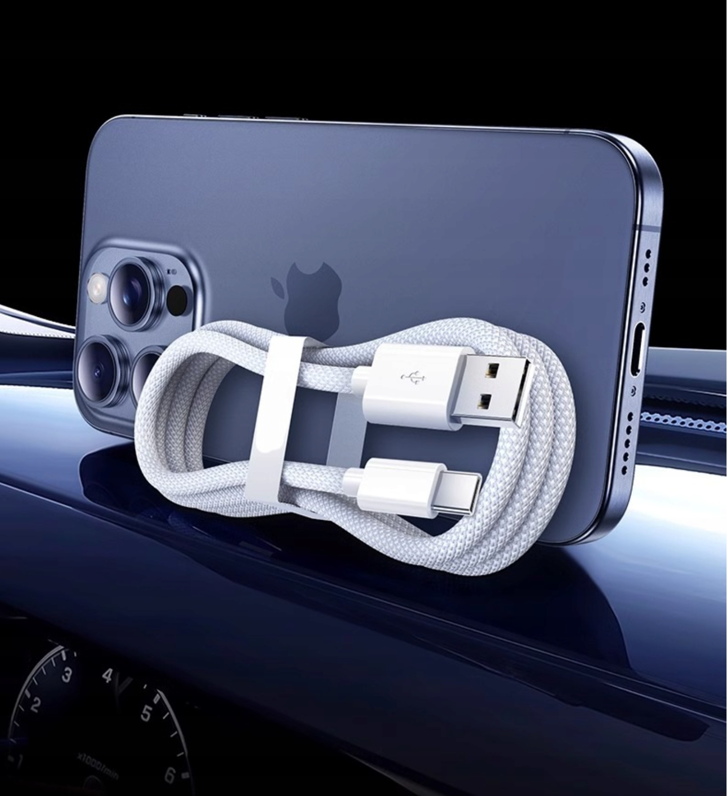 Niebieski iPhone i biały kabel ładujący na tle ciemnoniebieskiego wnętrza samochodu.