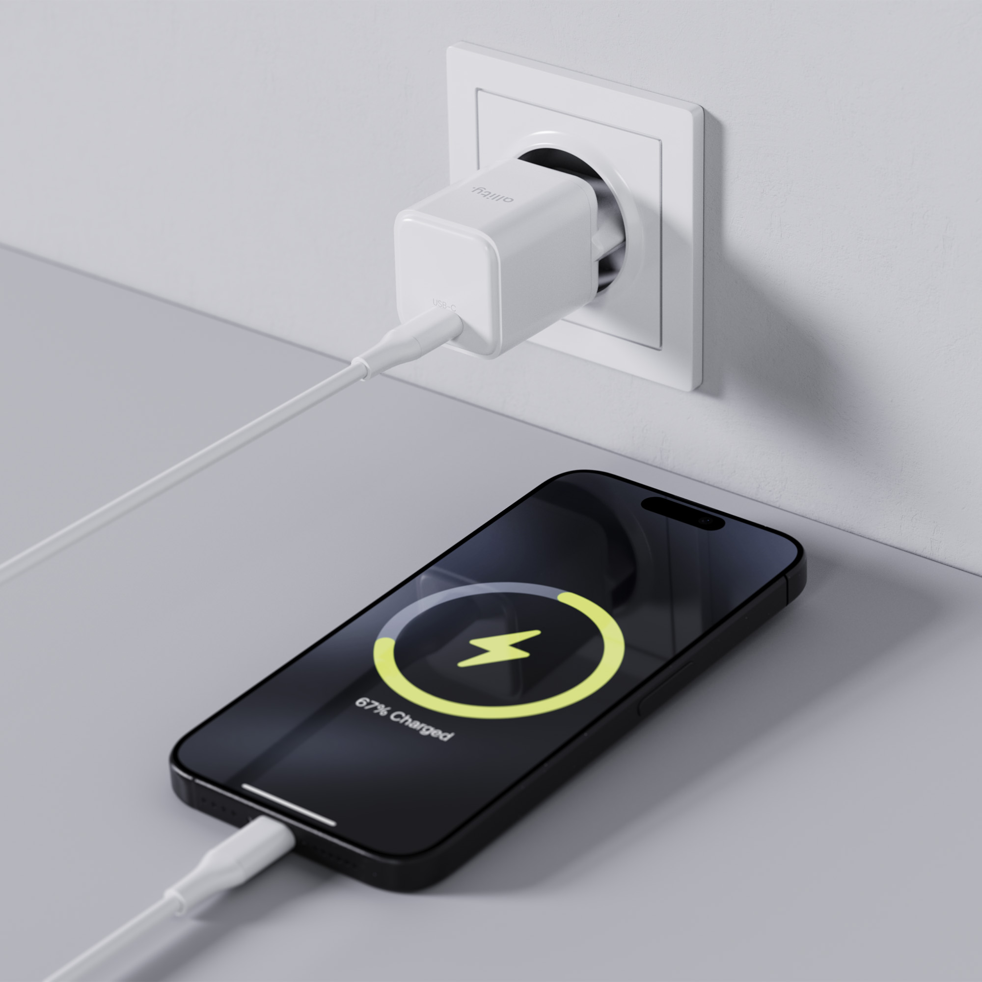 Czarny telefon ładujący się białym kablem w białej wtyczce, z ikoną ładowania na ekranie.