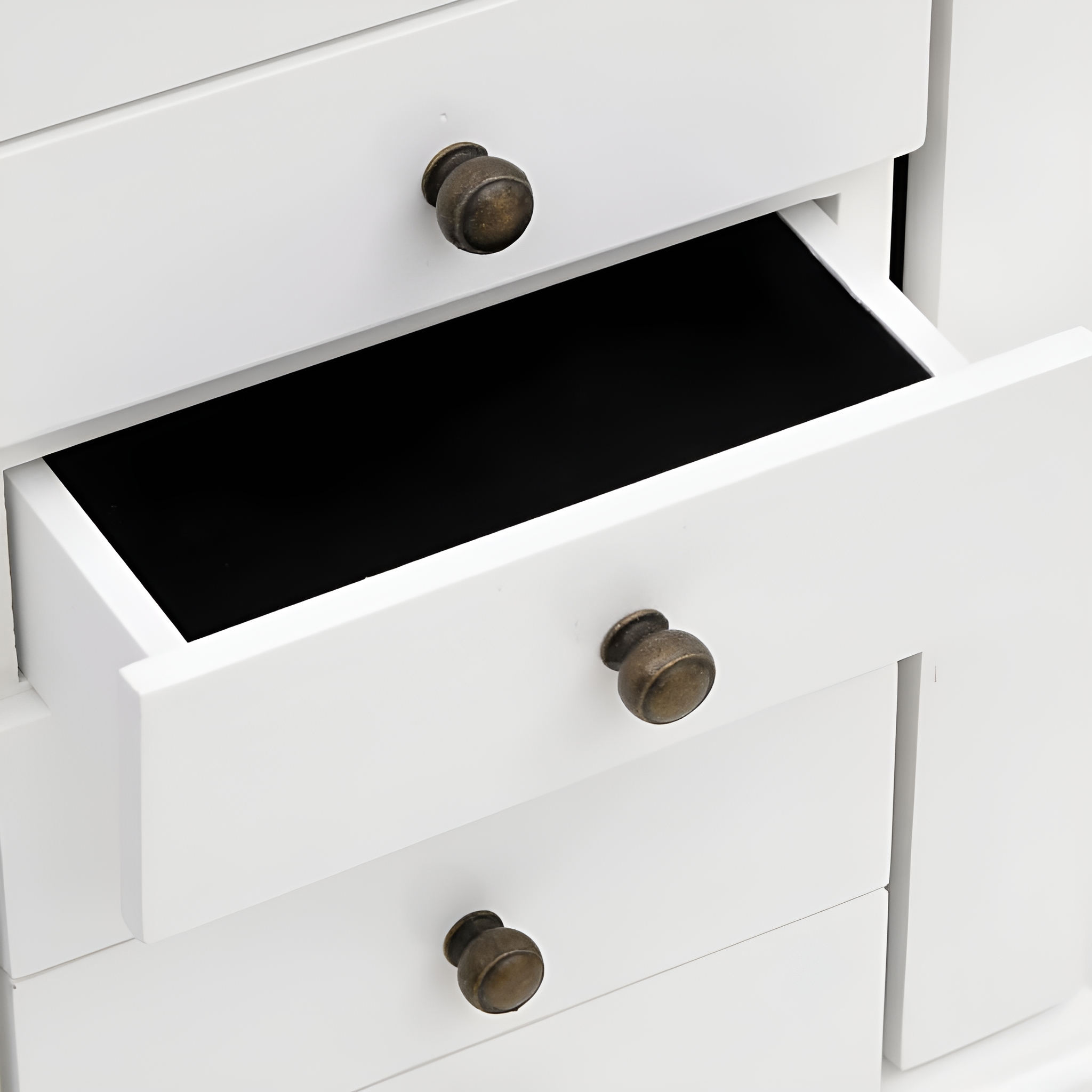 Weißer Schrank mit offener Schublade, die ein schwarzes Innere zeigt.