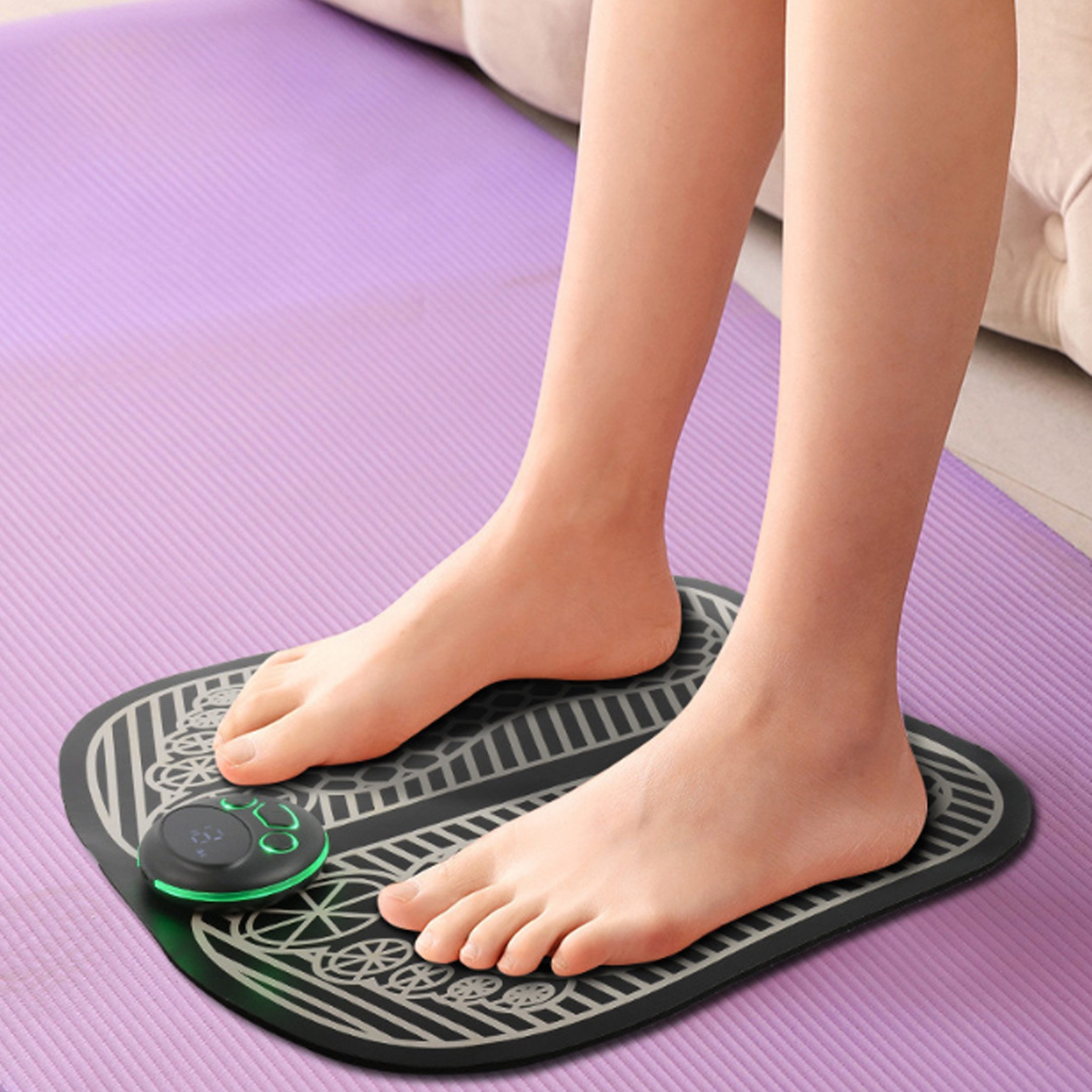 Füße einer Person auf einer Fußmassage-Matte, mit Bedienfeld und lila Yogamatte.