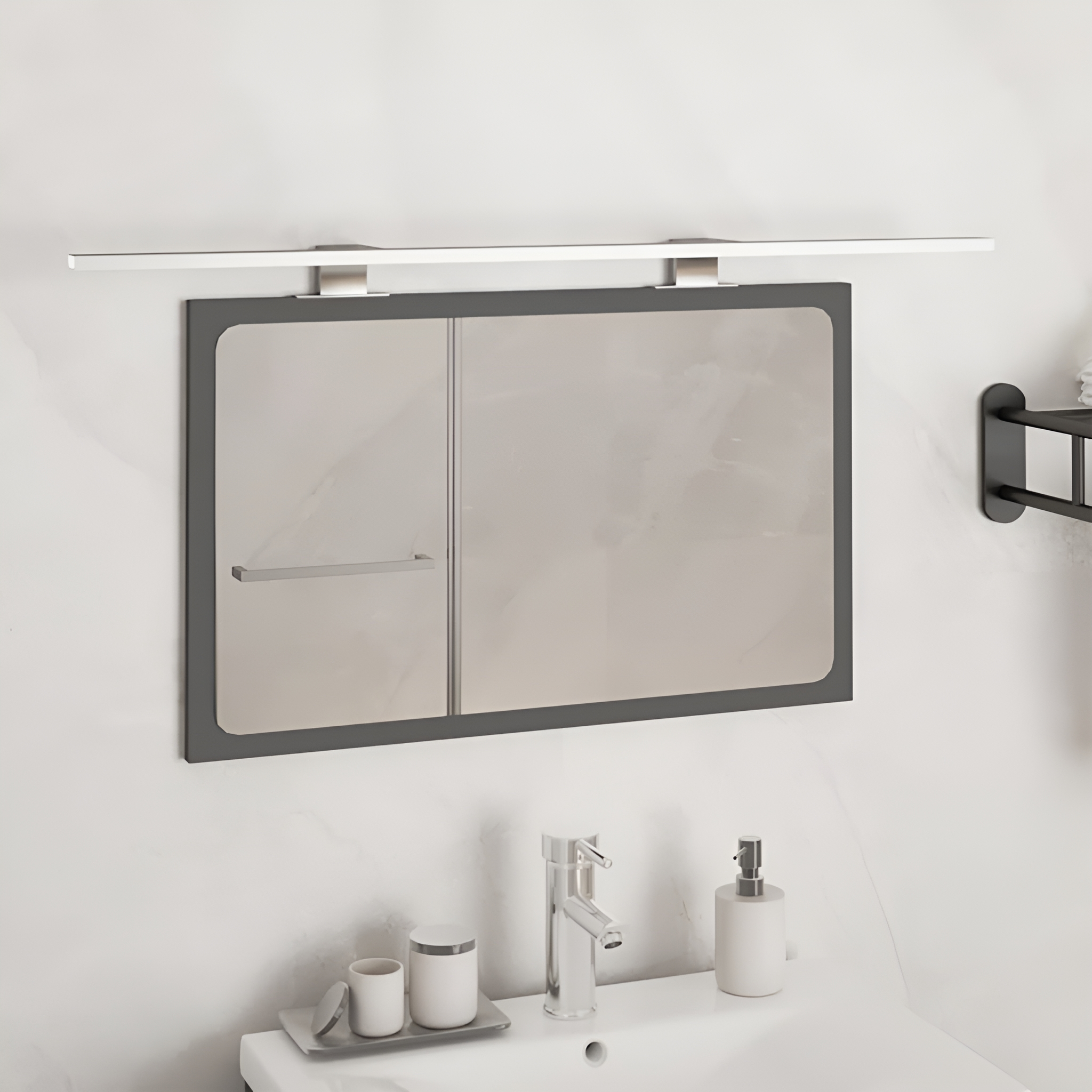 Badspiegel mit Lichtleiste, Waschbecken und Handtuchhalter.