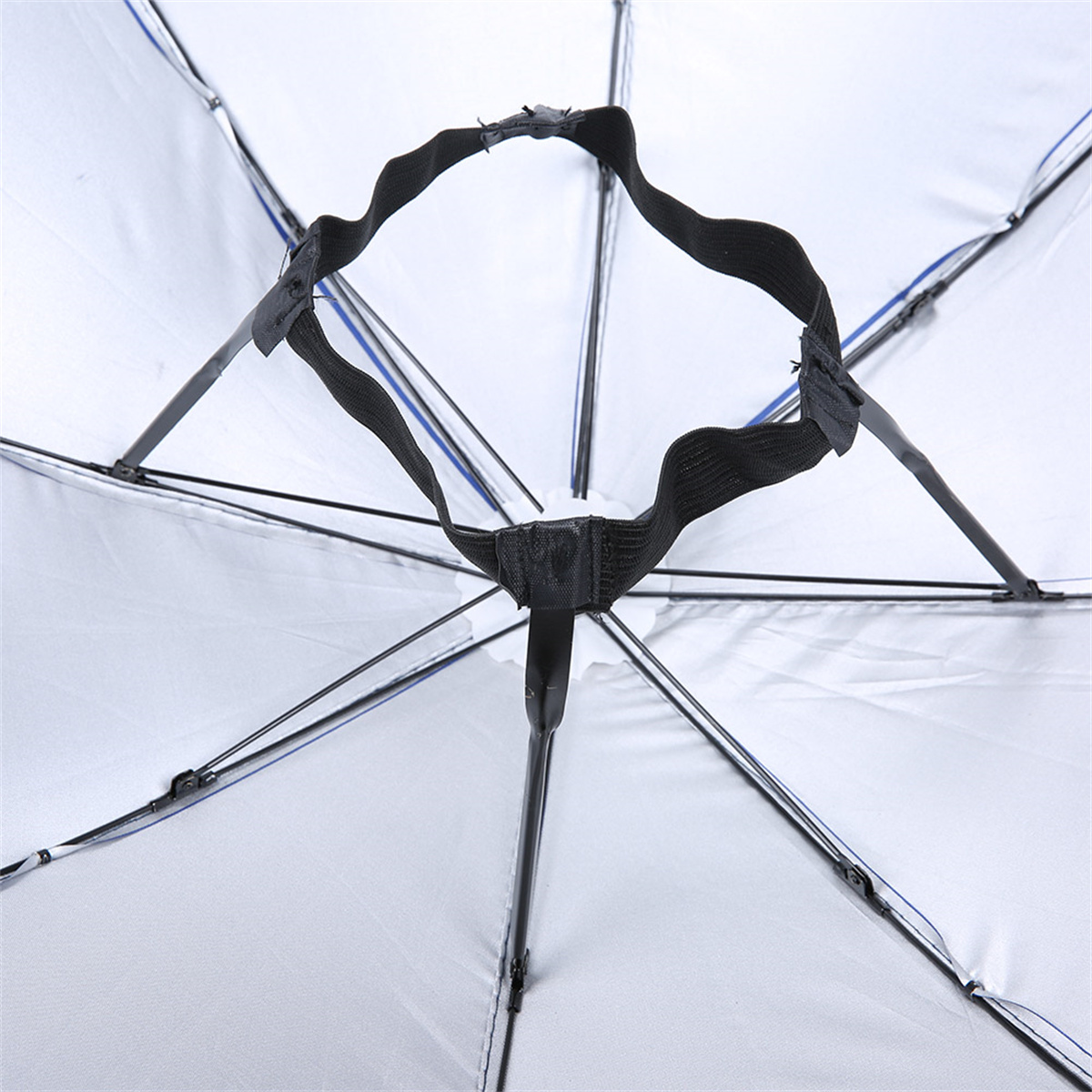 Die Innenseite eines weißen und schwarzen Regenschirms, der Rahmen ist sichtbar.