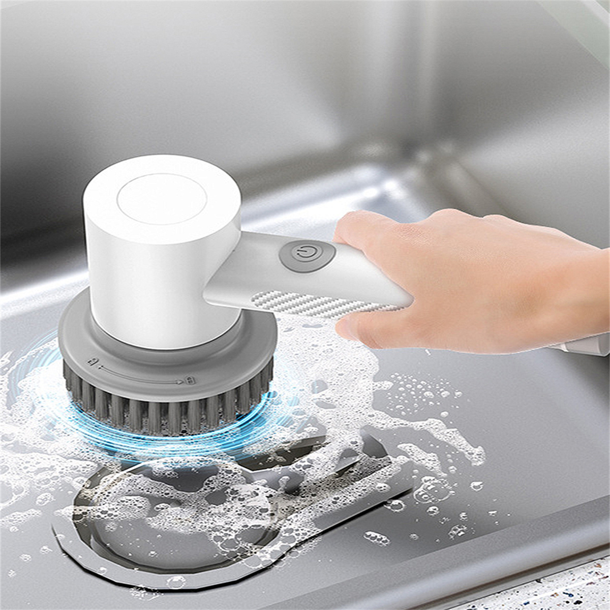 Eine Hand hält eine weiß-graue elektrische Bürste über einem Waschbecken mit Seifenlauge.