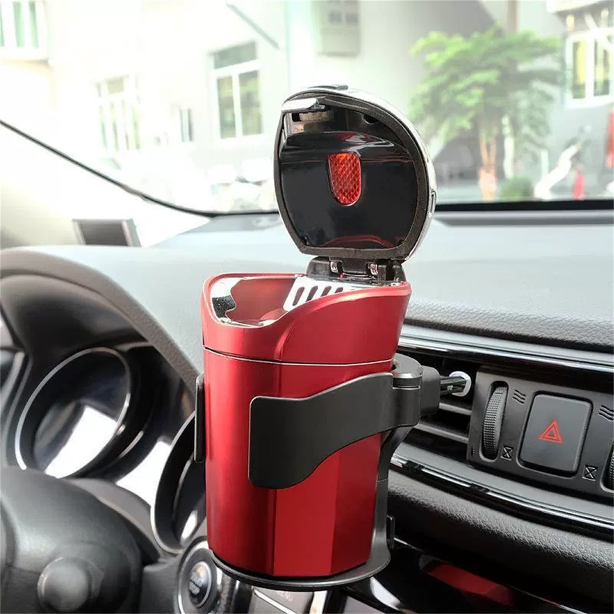 Ein roter Autoaschenbecher mit schwarzem Halter, offen, in einem Auto.