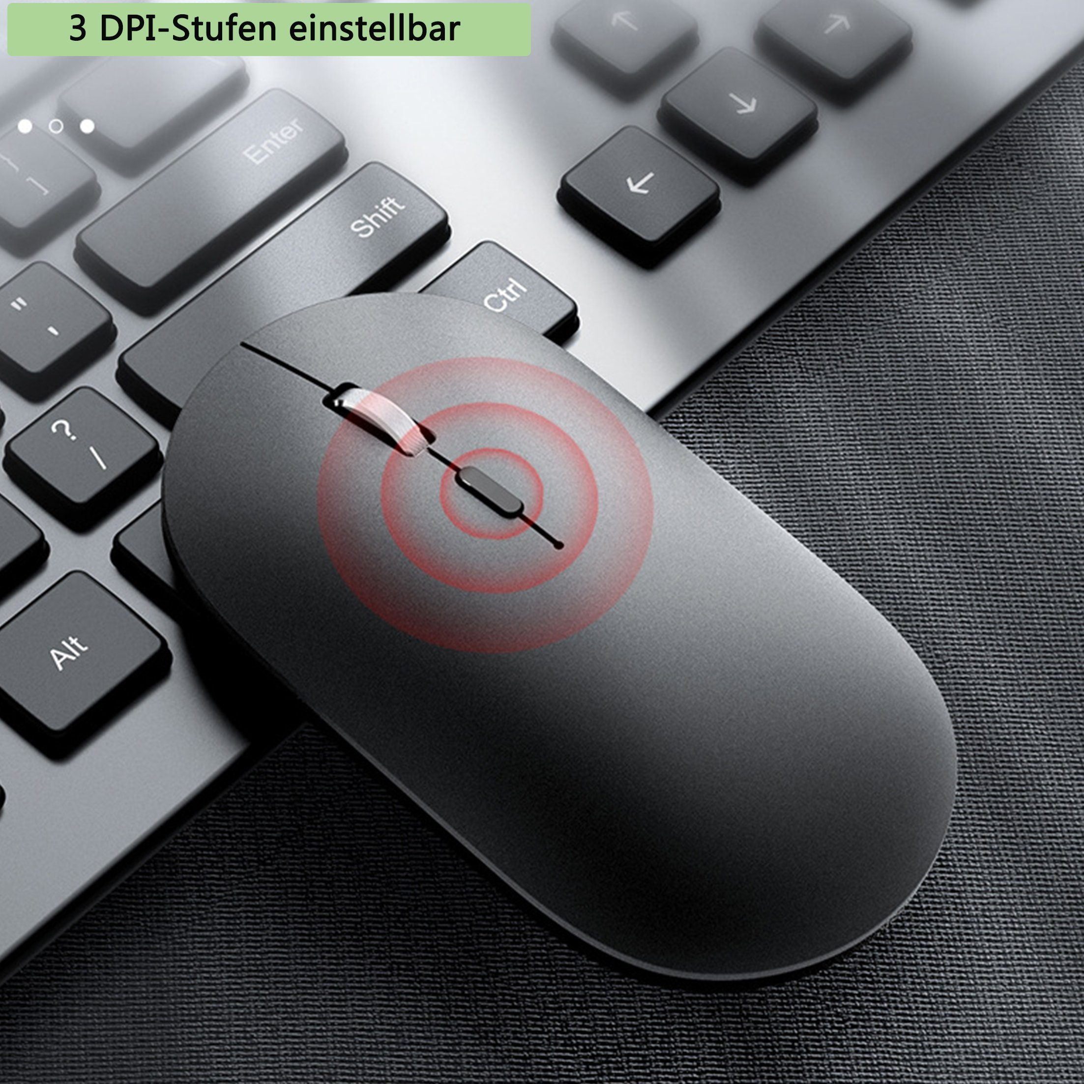 Eine schwarze kabellose Maus auf einem Schreibtisch mit Tastatur, rotes Licht.