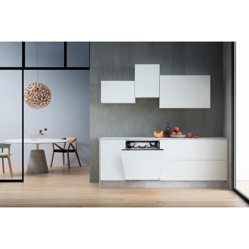 Nowoczesna kuchnia z białymi szafkami, wbudowaną zmywarką i drewnianą podłogą.