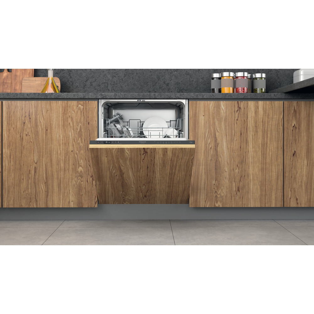 Lavastoviglie Whirlpool integrata in un mobile cucina in legno. La porta è aperta, rivelando l'interno.