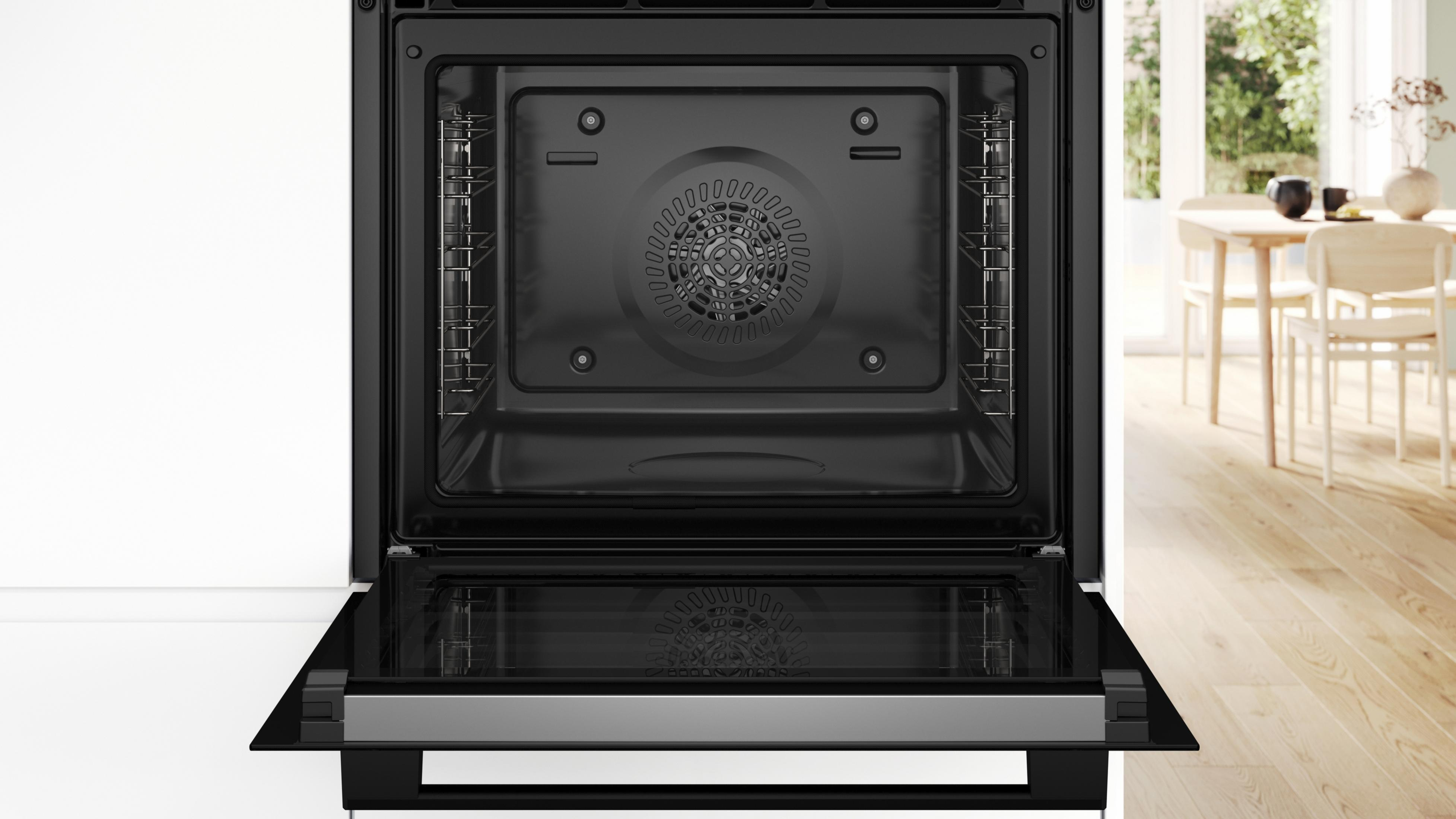 Interno forno aperto con ventola, luci e sfondo visibile.