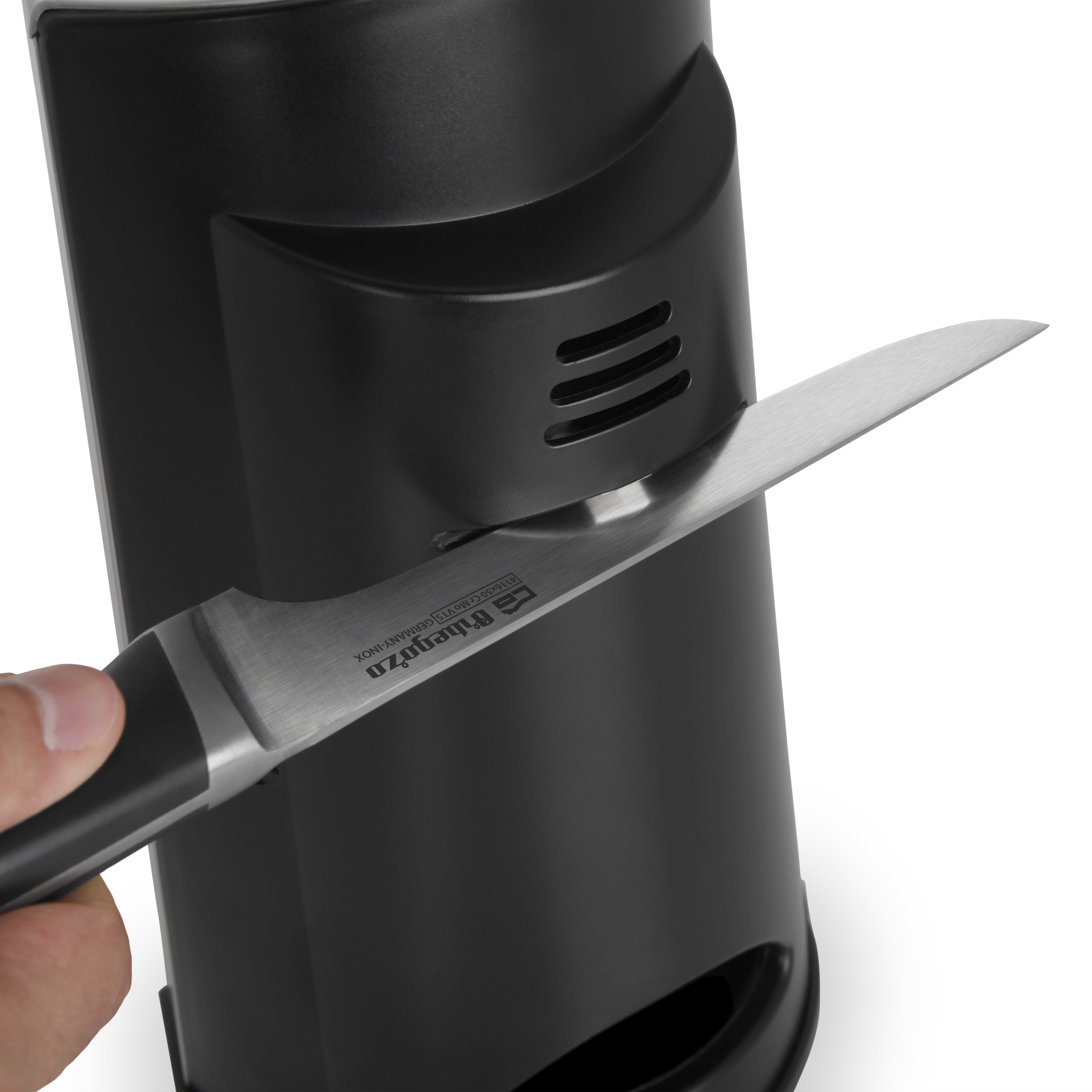 Se está afilando un cuchillo al introducirlo en un afilador de cuchillos negro.