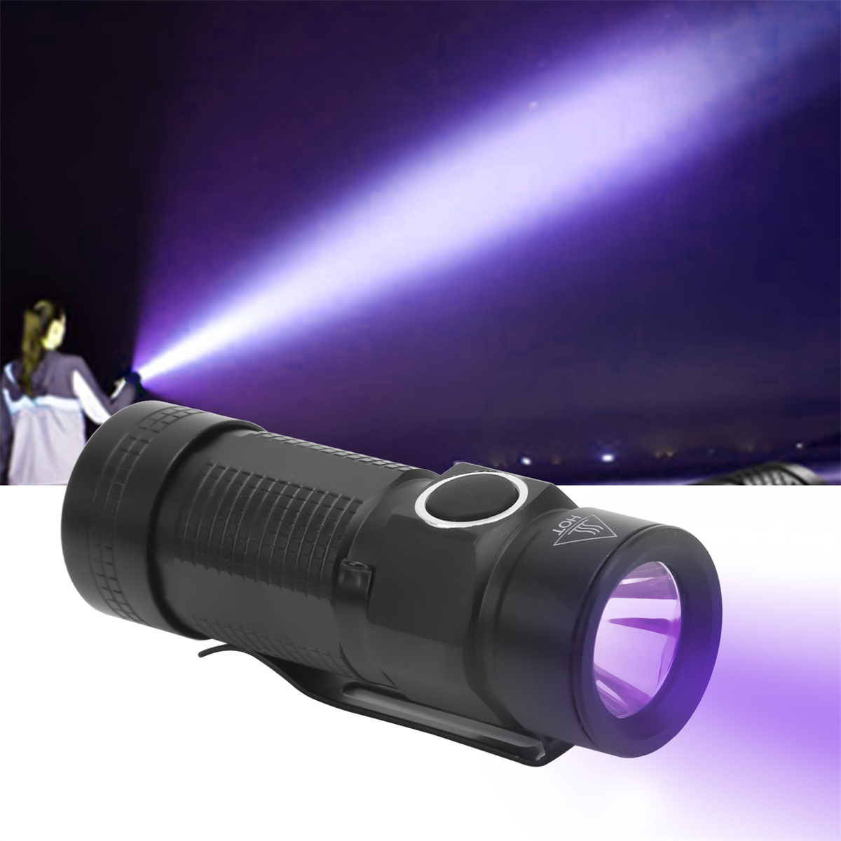 Eine schwarze Taschenlampe strahlt einen violetten Strahl in den Nachthimmel. Eine Person hält das Licht.
