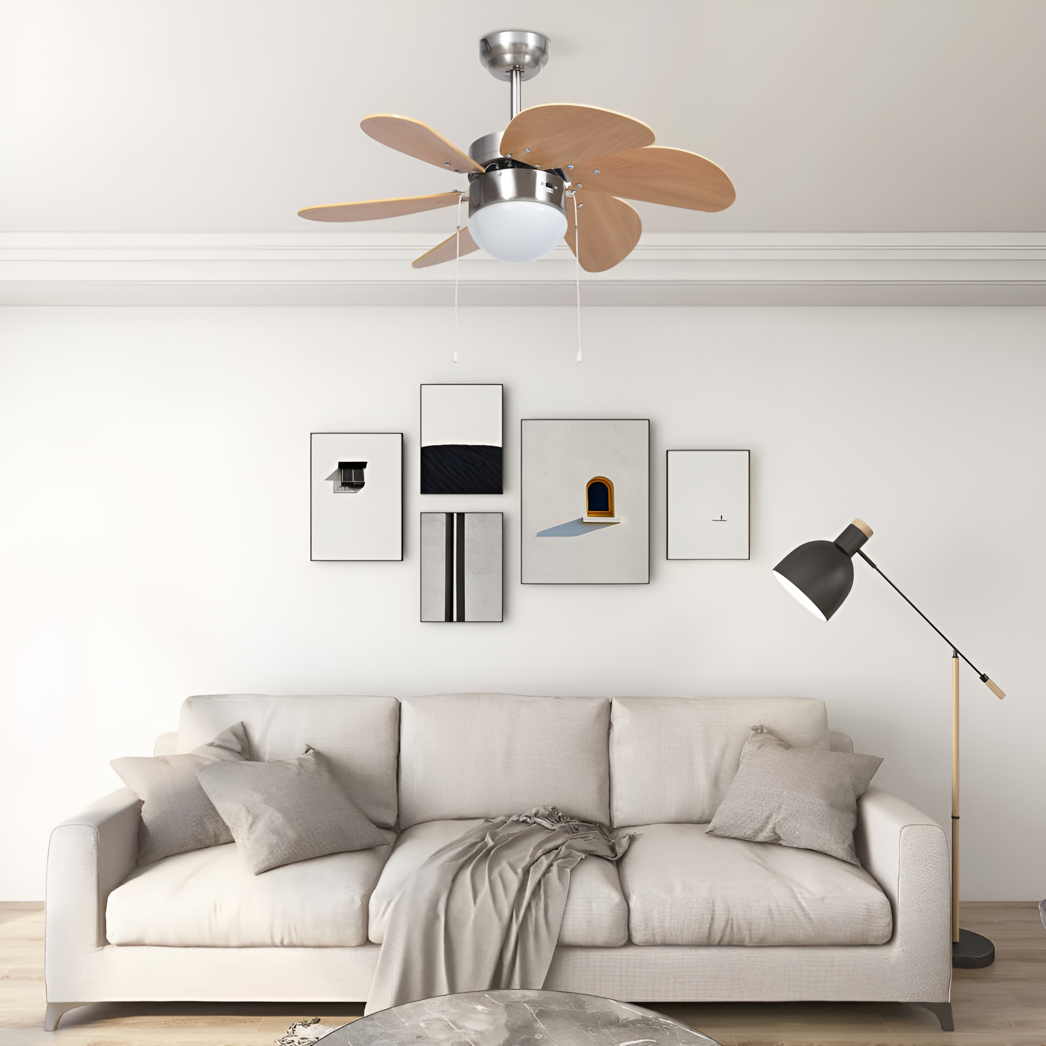 Wohnzimmer mit Deckenventilator, weißem Sofa, Kunstwerken und einer Stehlampe.