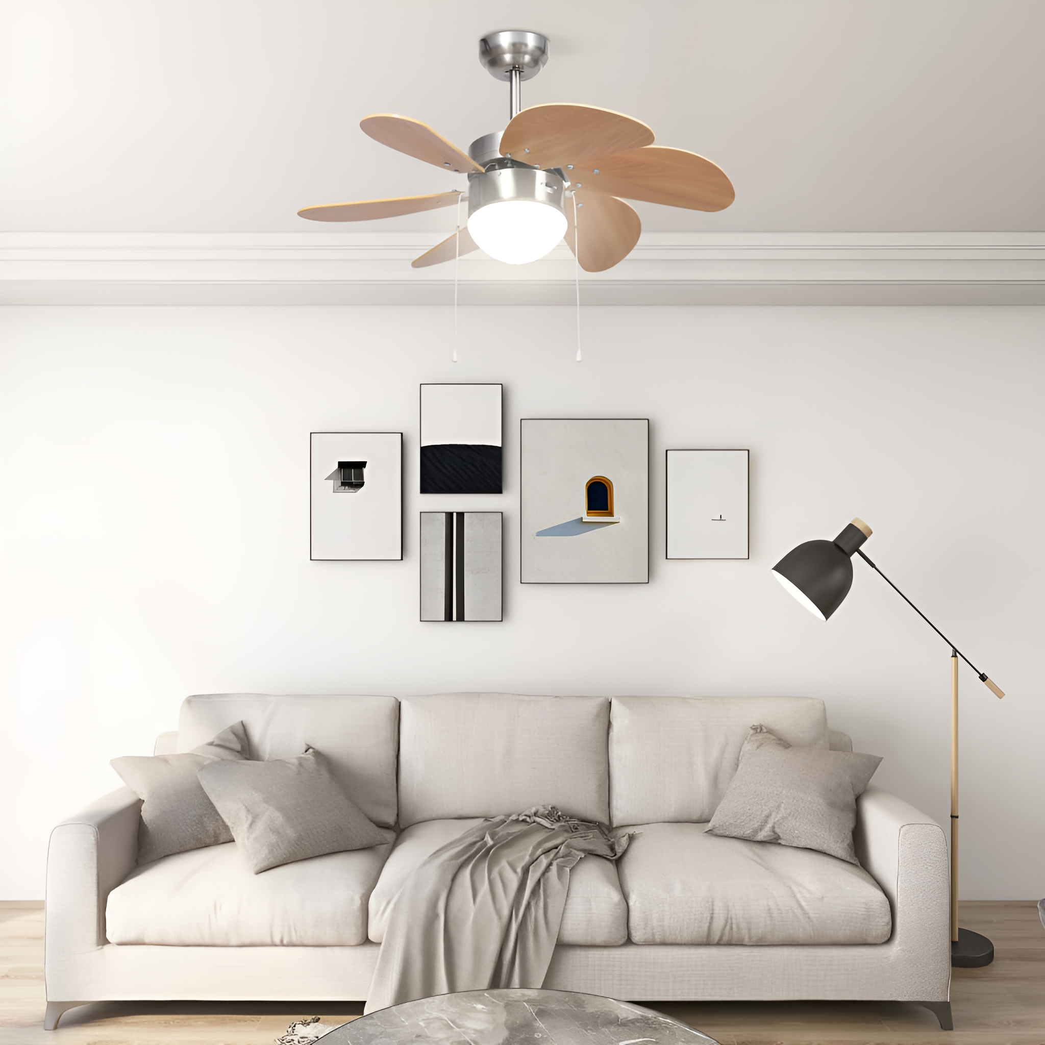 Ein Raum mit Deckenventilator, Sofa und Kunstwerken. Eine schwarze Stehlampe steht neben dem Sofa.