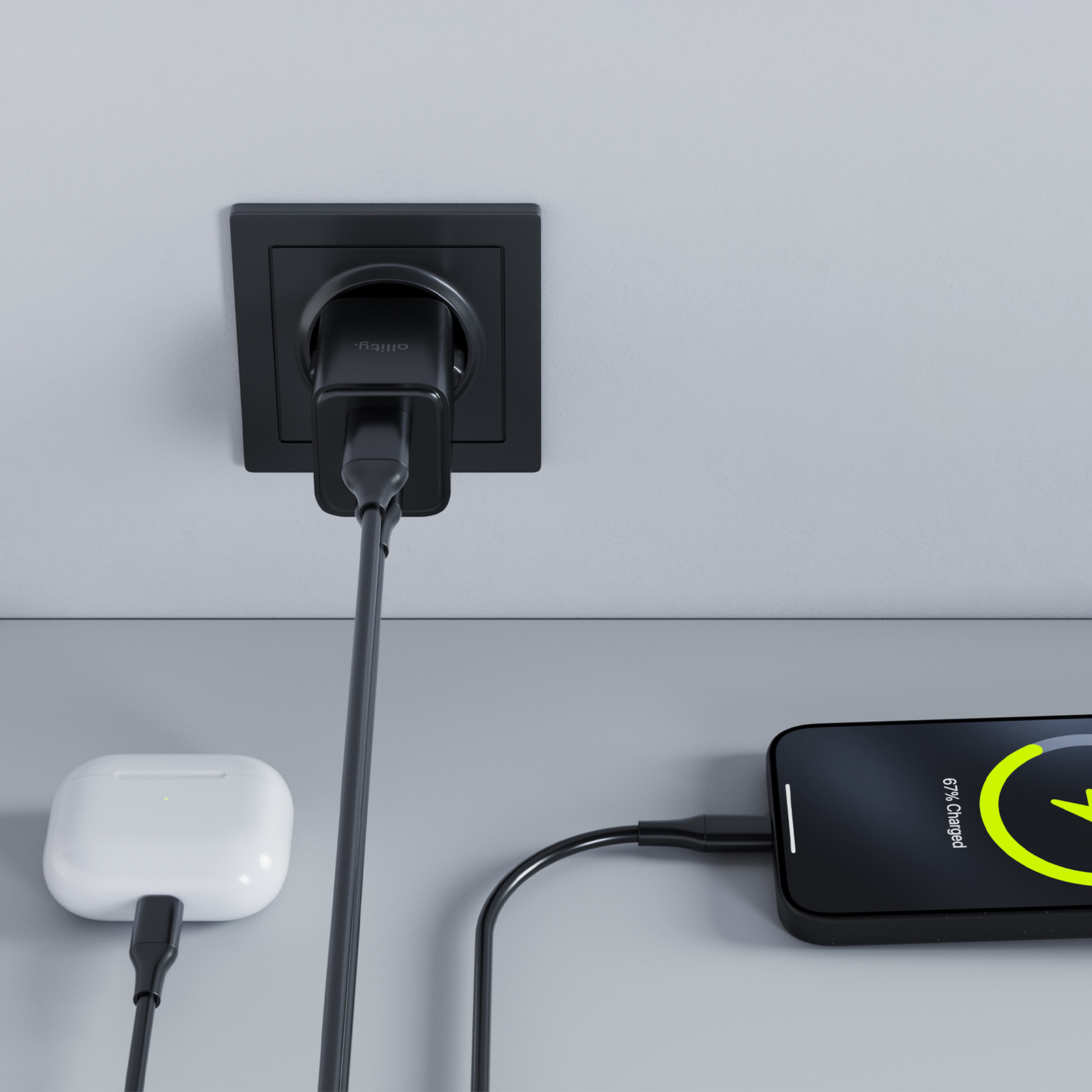 Ładowarka podłączona, ładująca telefon i słuchawki. 67% naładowania.