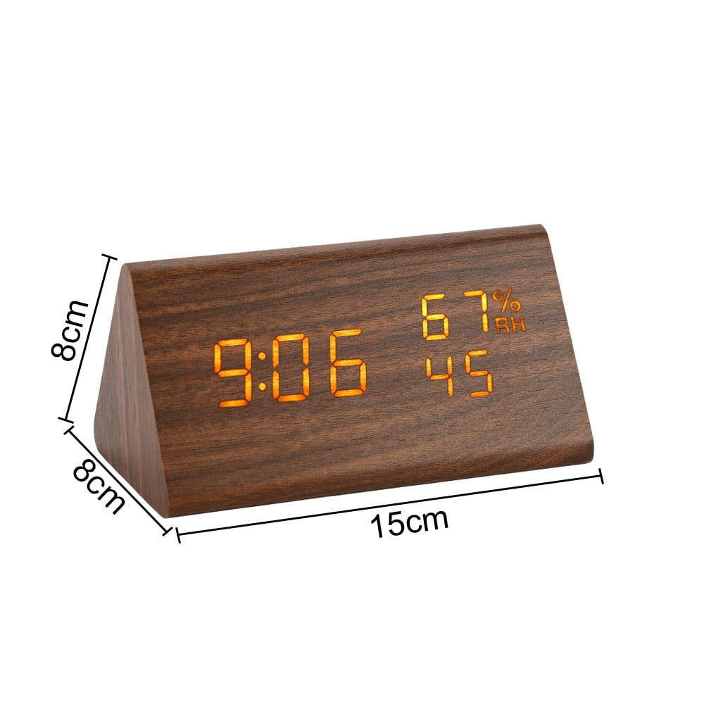 Eine hölzerne dreieckige Uhr zeigt 9:06, 67% und 45 an. Abmessungen sind 15x8x8 cm.