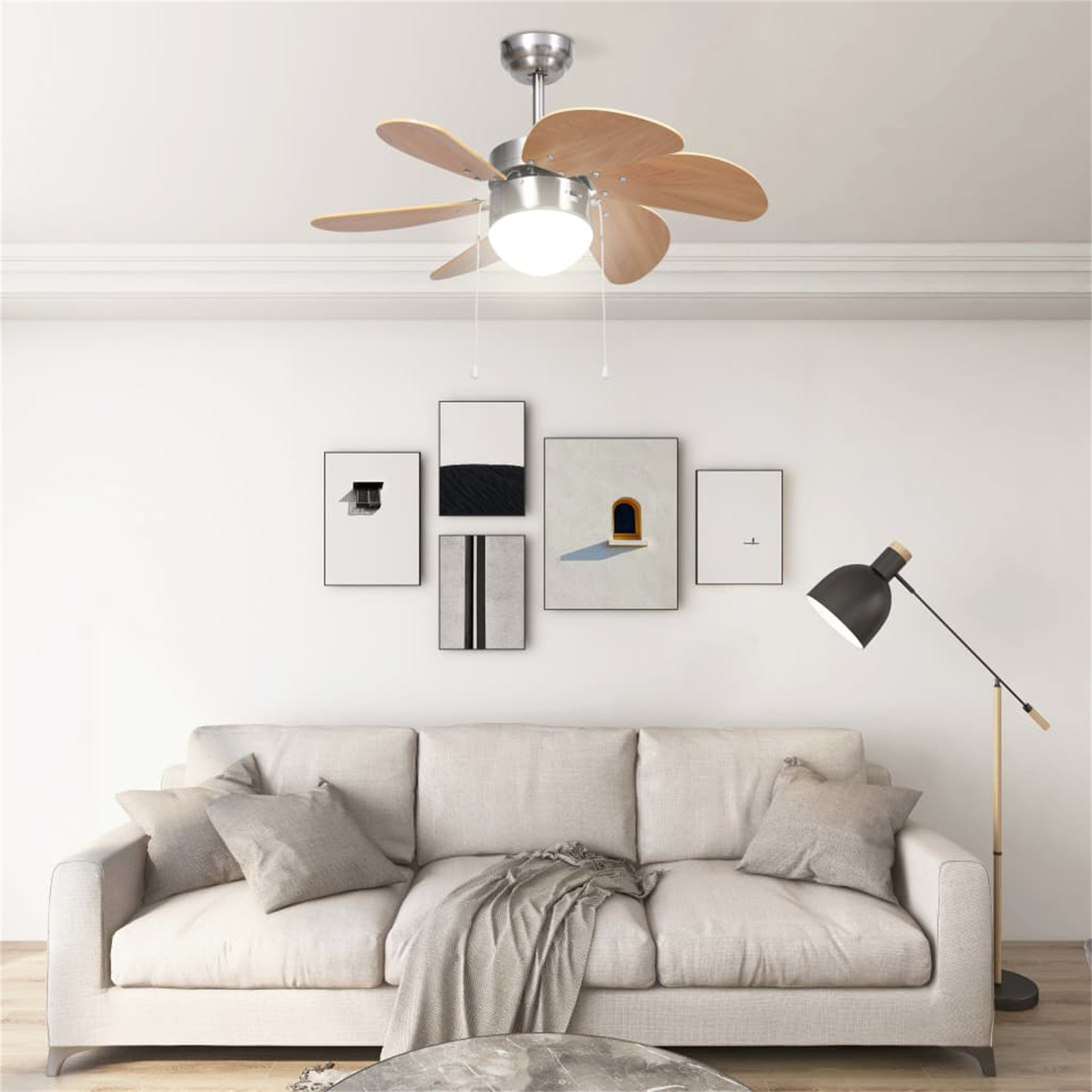 Wohnzimmer mit Deckenventilator, Kunstwerken, Sofa und Stehlampe.
