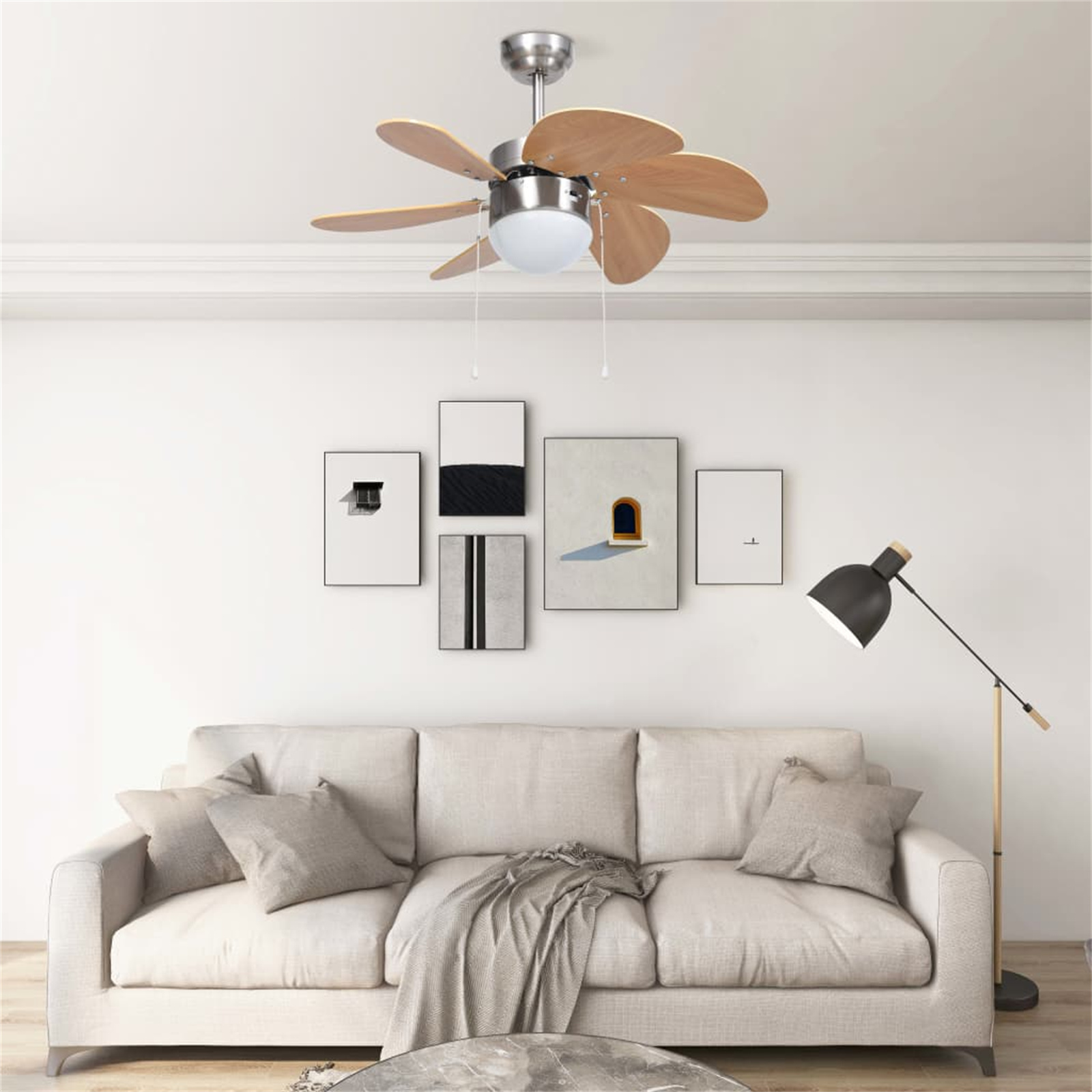 Deckenventilator mit Holzflügeln, weiße Wände, Sofa, Kunstwerk und Stehlampe.
