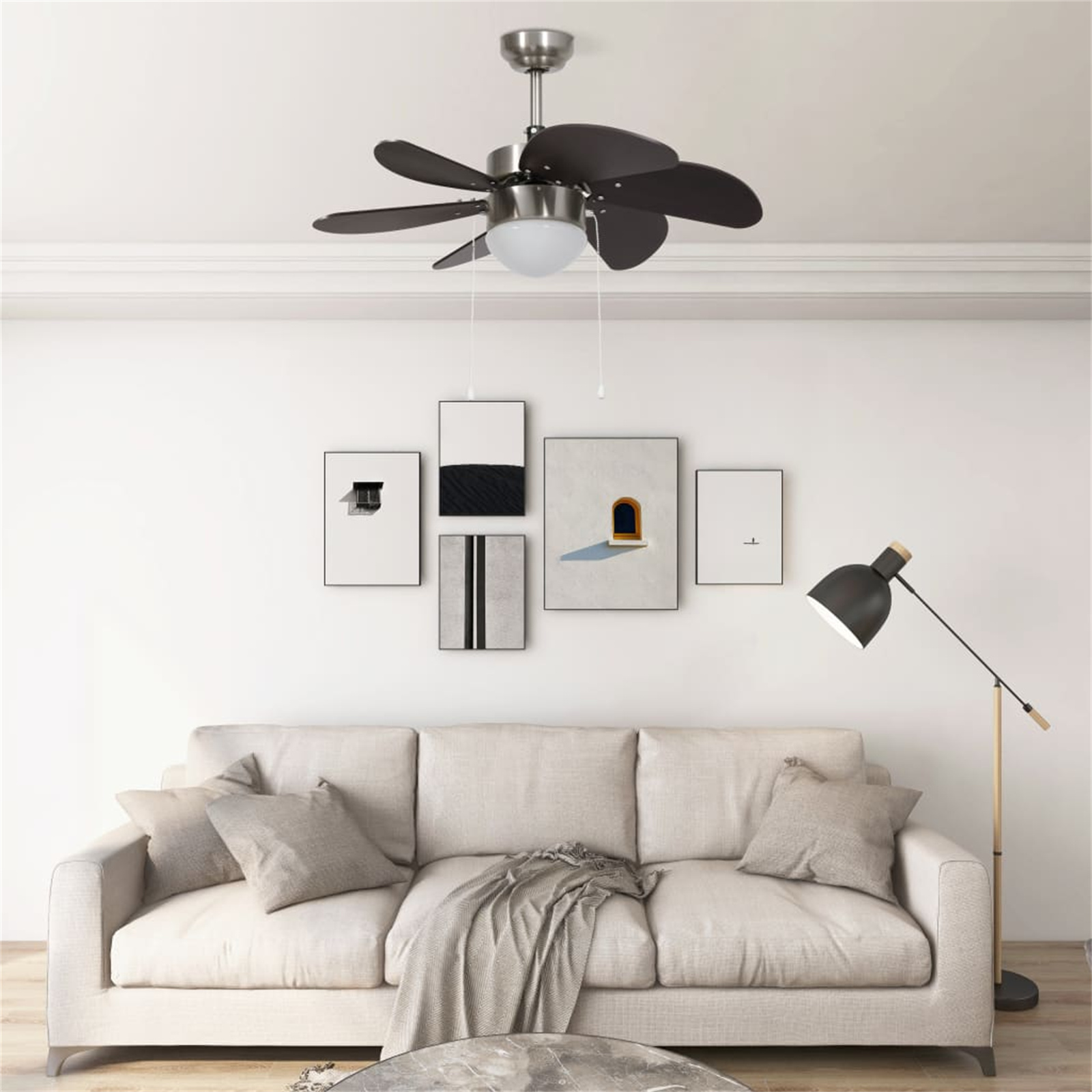 Wohnzimmer mit Deckenventilator, Sofa, Kunstwerken und Stehlampe.