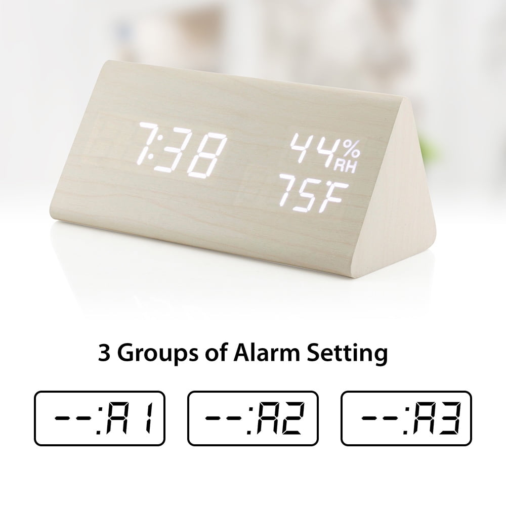 Eine hölzerne dreieckige Uhr mit weißen Ziffern, die Zeit, Luftfeuchtigkeit und Temperatur anzeigt.
