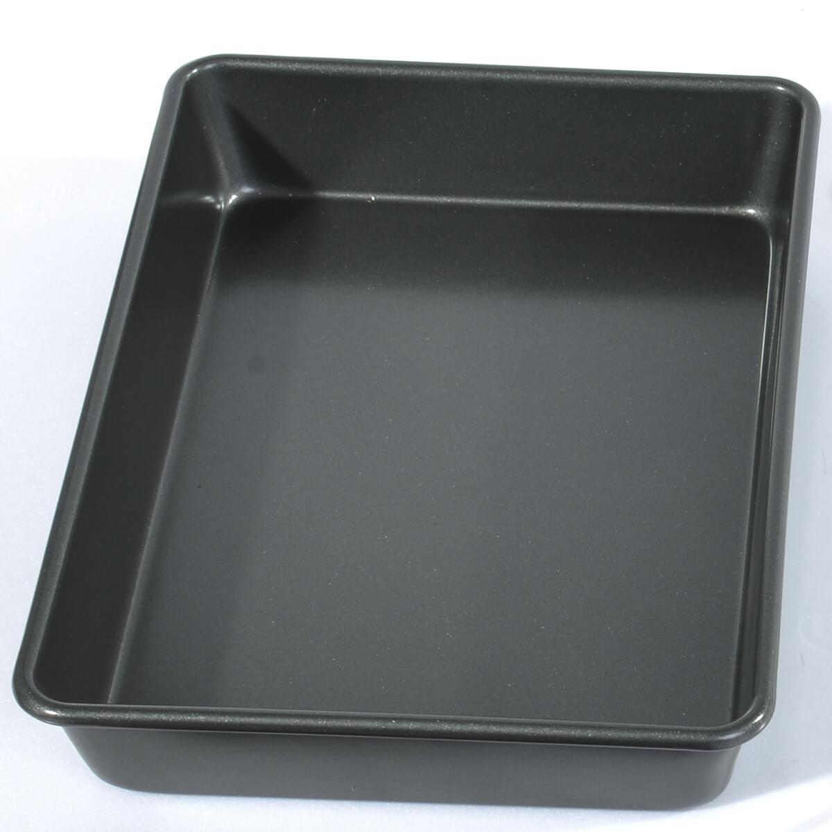 Prostokątna, ciemnoszara blacha do pieczenia, pusta i widziana z lekkiego uniesienia.