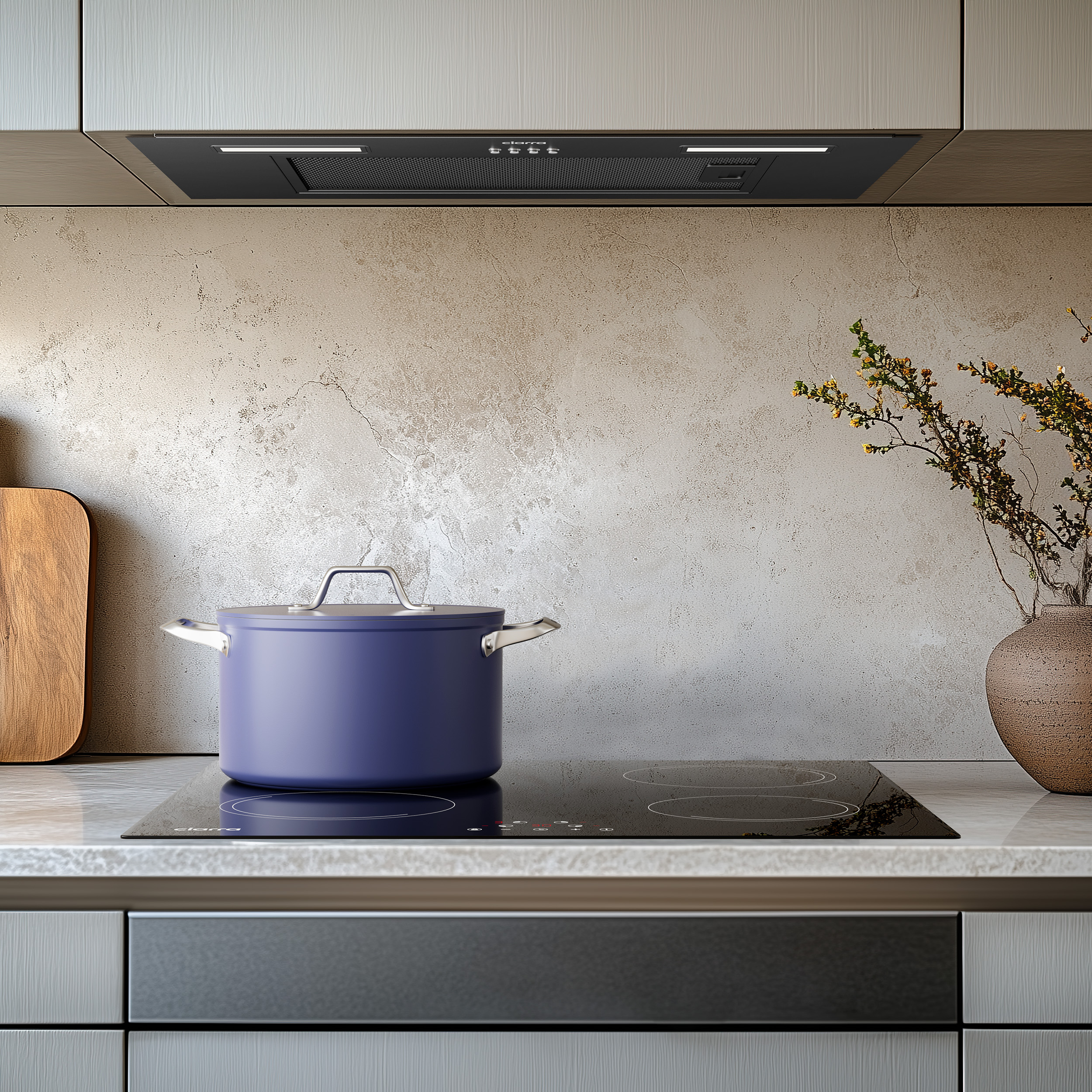 Een keukenscène met een blauwe pan op een zwart fornuis en een afzuigkap erboven. Beige muur en een houten plank.