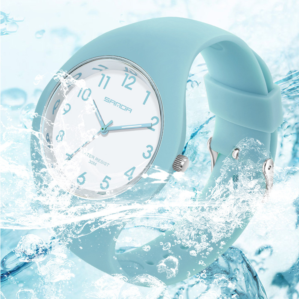 Eine hellblaue Uhr mit weißem Zifferblatt, umgeben von Wasserspritzern.