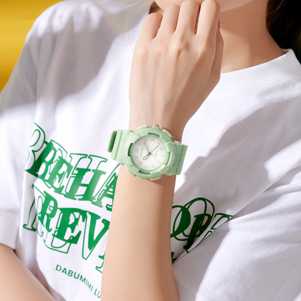 Das Handgelenk einer Person mit einer grünen Uhr.