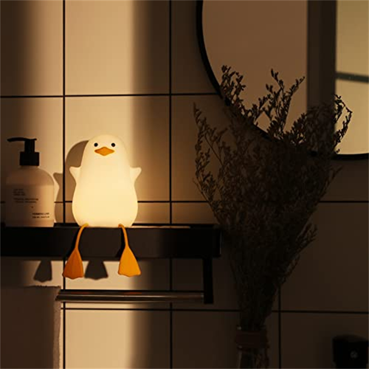 Ein pinguinförmiges Nachtlicht in einem Badezimmer, mit Spiegel und Pflanze im Hintergrund.