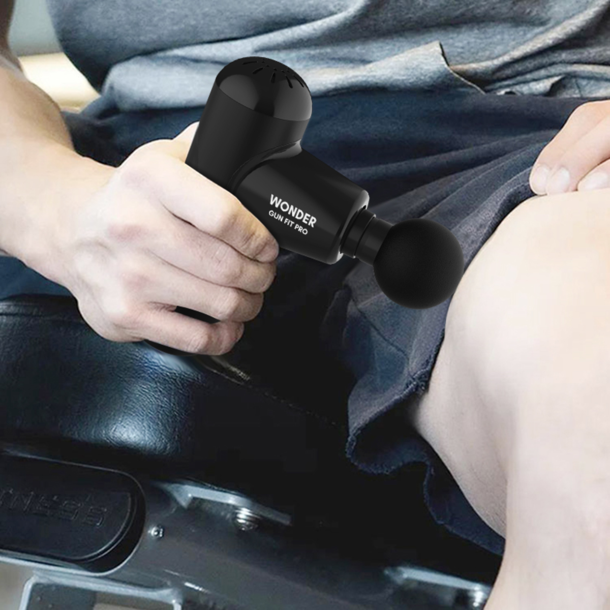 Person verwendet eine schwarze Massagepistole am Bein. Gerät hat die Marke Wonder Gun Fit Pro.