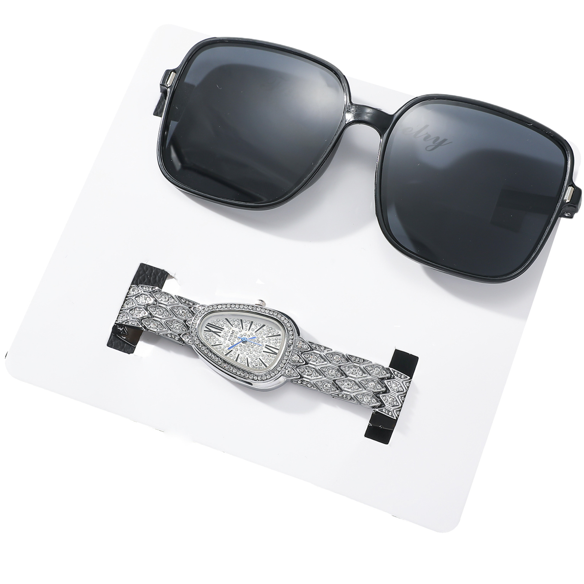 Eine Uhr mit diamantbesetztem Armband und eine schwarze Sonnenbrille auf einer weißen Oberfläche.