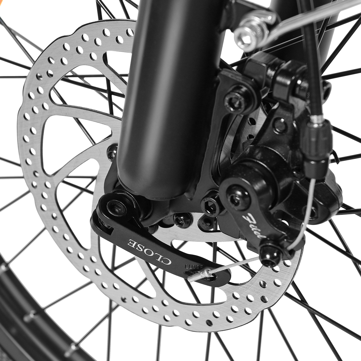 Zbliżenie tarczy hamulcowej i komponentów roweru. Tarcza jest srebrna, zacisk czarny.