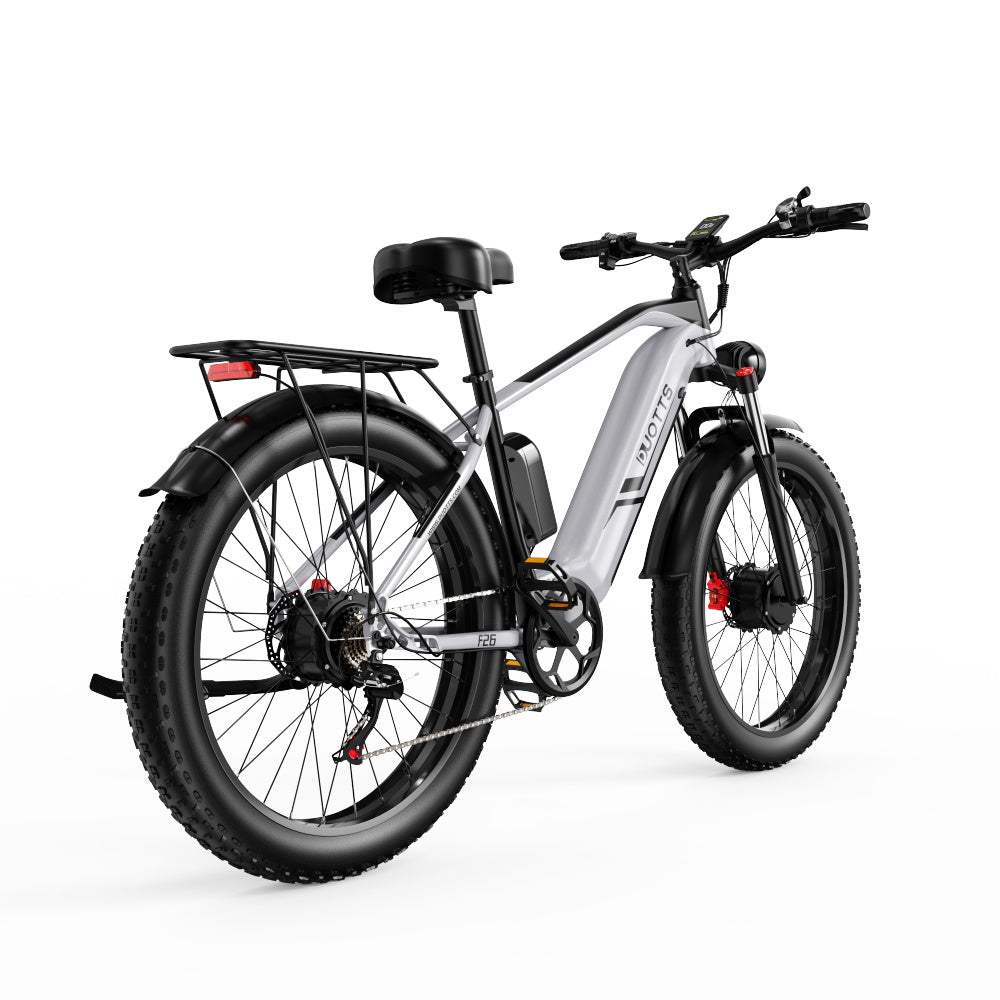 Bicicletta elettrica con telaio grigio, pneumatici neri e portapacchi. Sfondo bianco.