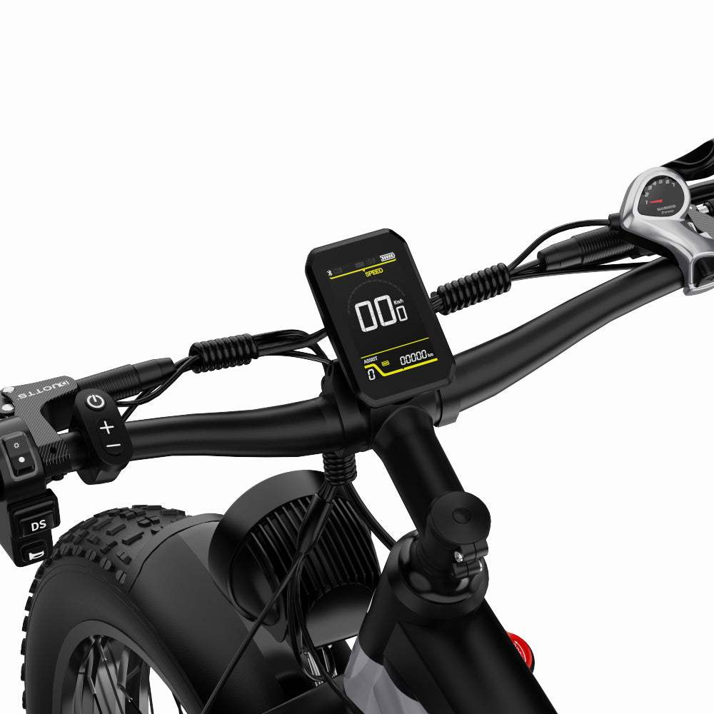 Manubrio di e-bike con display che mostra velocità e distanza. I comandi sono sui lati sinistro e destro.