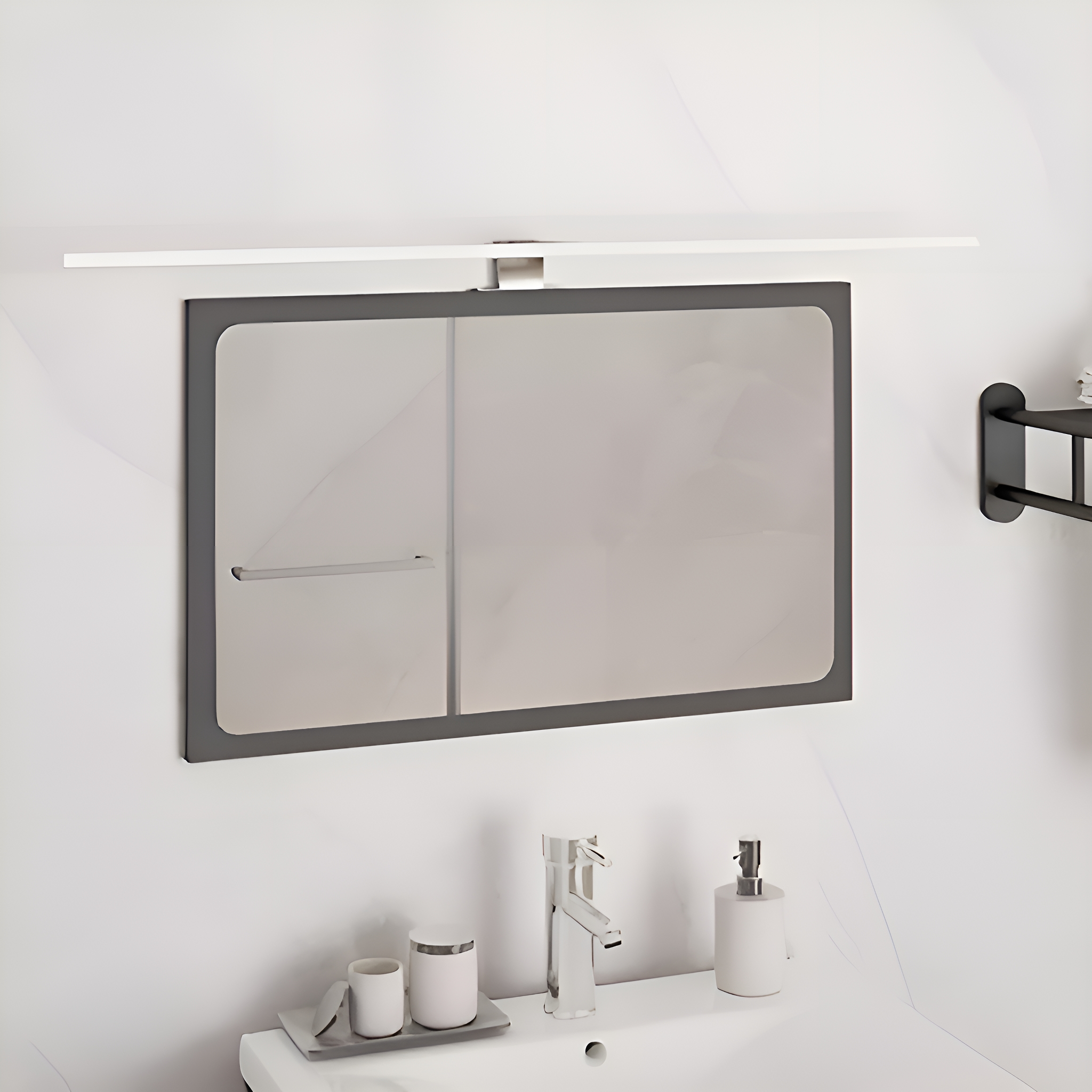 Spiegel über einem Waschbecken mit Wasserhahn und Seifenspender, weißes und graues Design.