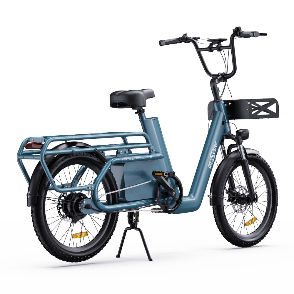 E-bike cargo verde acqua con portapacchi. Manubrio, cestino, ruote neri e cavalletto.