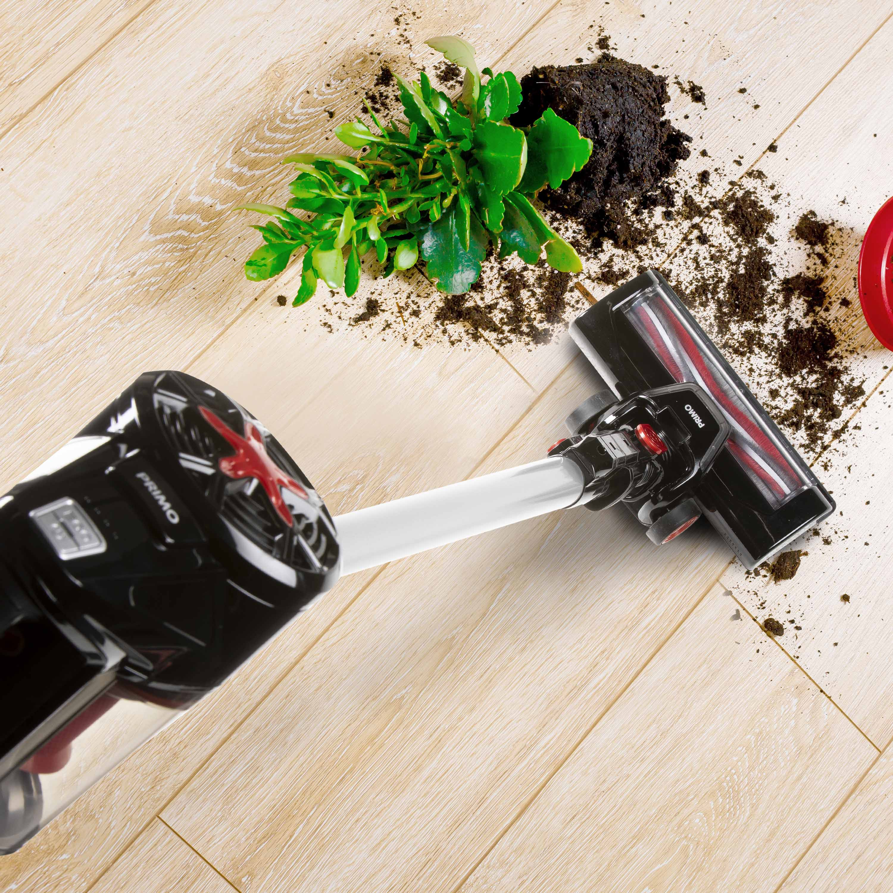 Un aspirateur avec un corps noir et une tête de brosse accentuée de rouge nettoyant un sol en bois avec de la saleté.