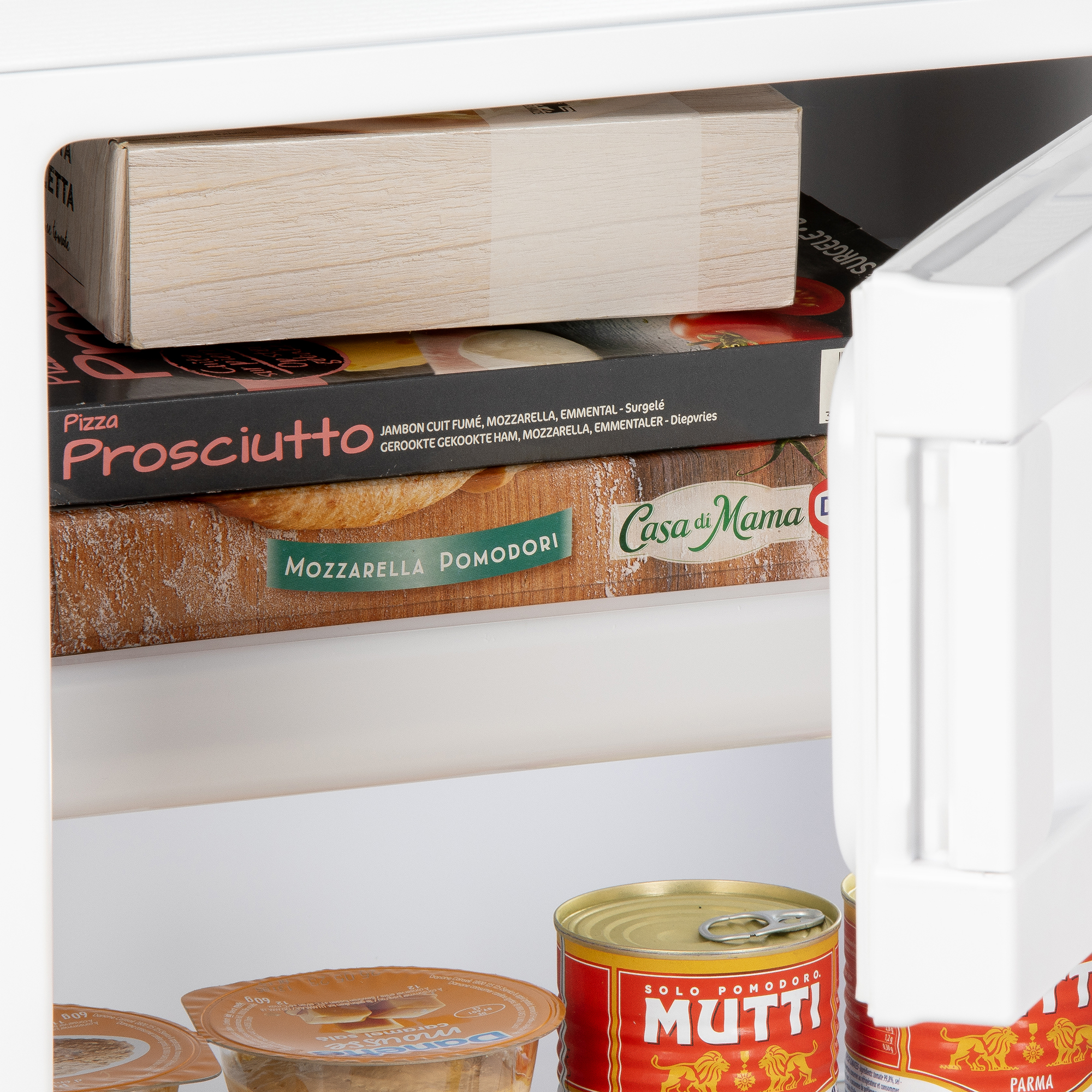 À l'intérieur d'un réfrigérateur avec des pizzas surgelées, des conserves et d'autres aliments.