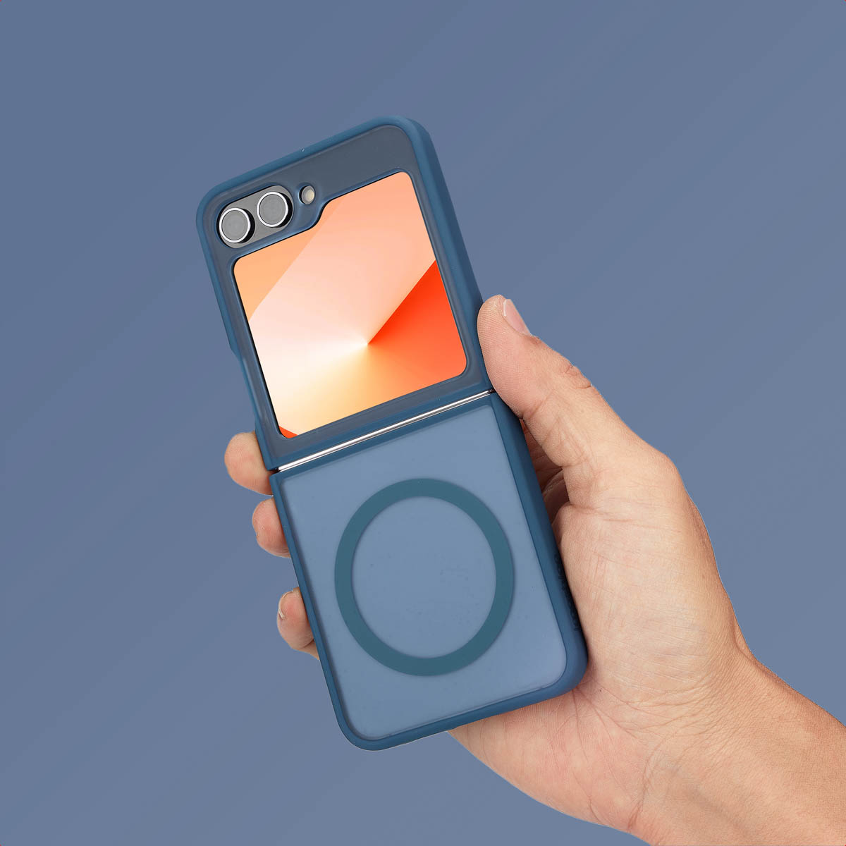 Een hand die een blauwe telefoonhoes vasthoudt met een oranje scherm. Hoes heeft cirkel en camera's.