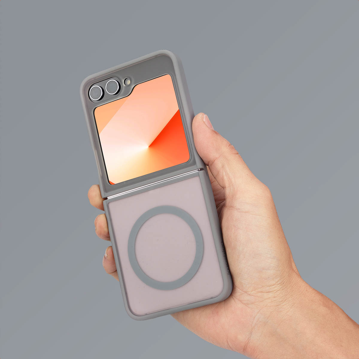 Een hand die een telefoon vasthoudt in een grijze case. Het scherm toont een oranje en witte gradiënt.