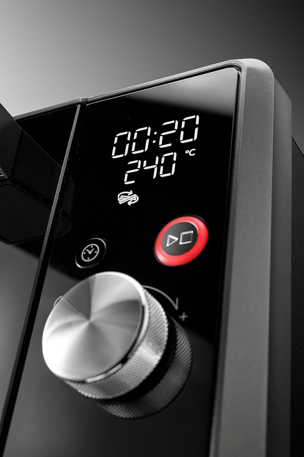 Zbliżenie czarnego panelu sterowania piekarnika z wyświetlaczem pokazującym czas i temperaturę.