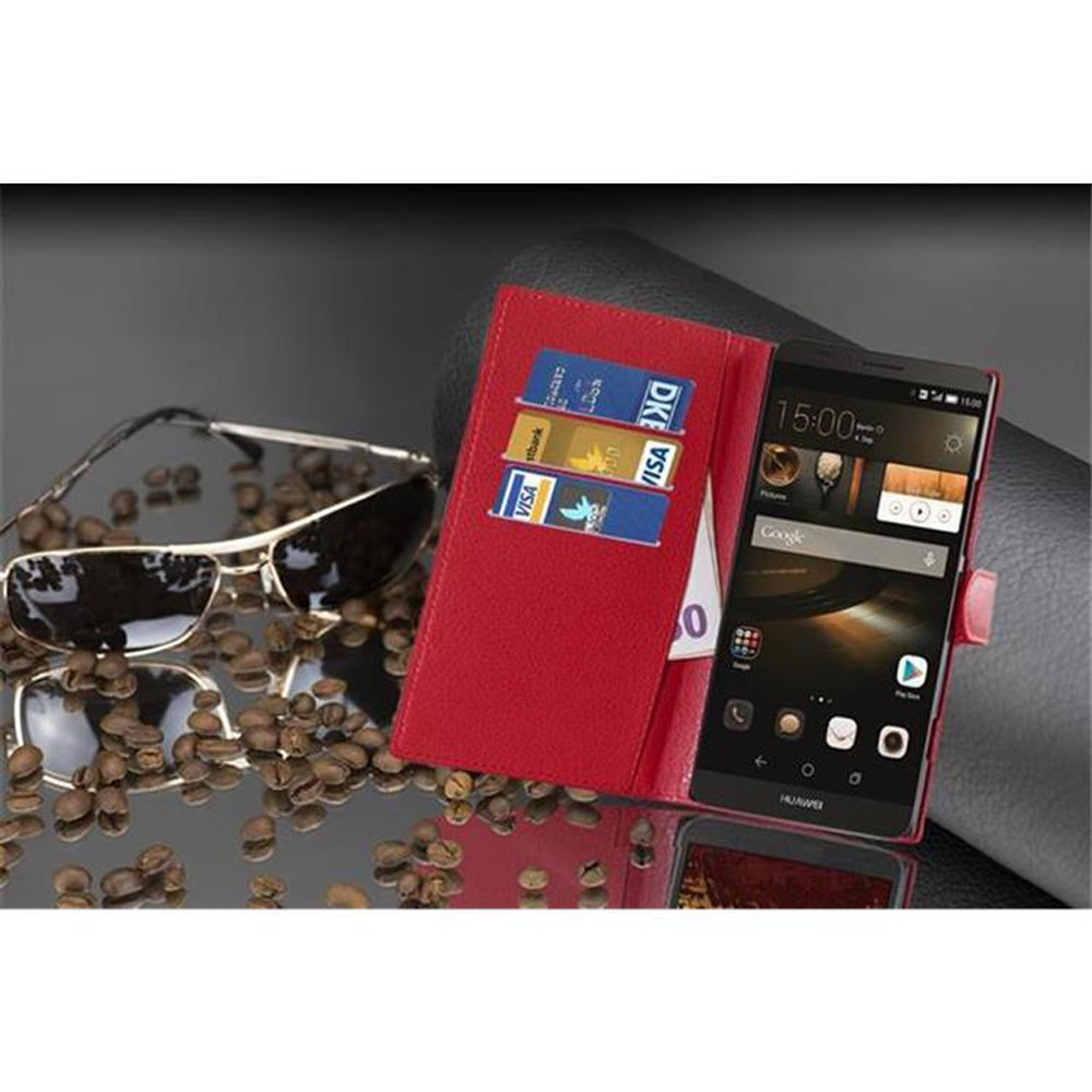 Telefono in custodia rossa con carte di credito, occhiali da sole e chicchi di caffè su una superficie.