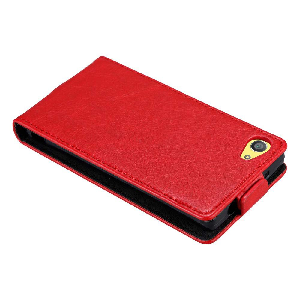 Custodia rossa per telefono, aperta. Interno nero, dettaglio fotocamera giallo. Superficie bianca.