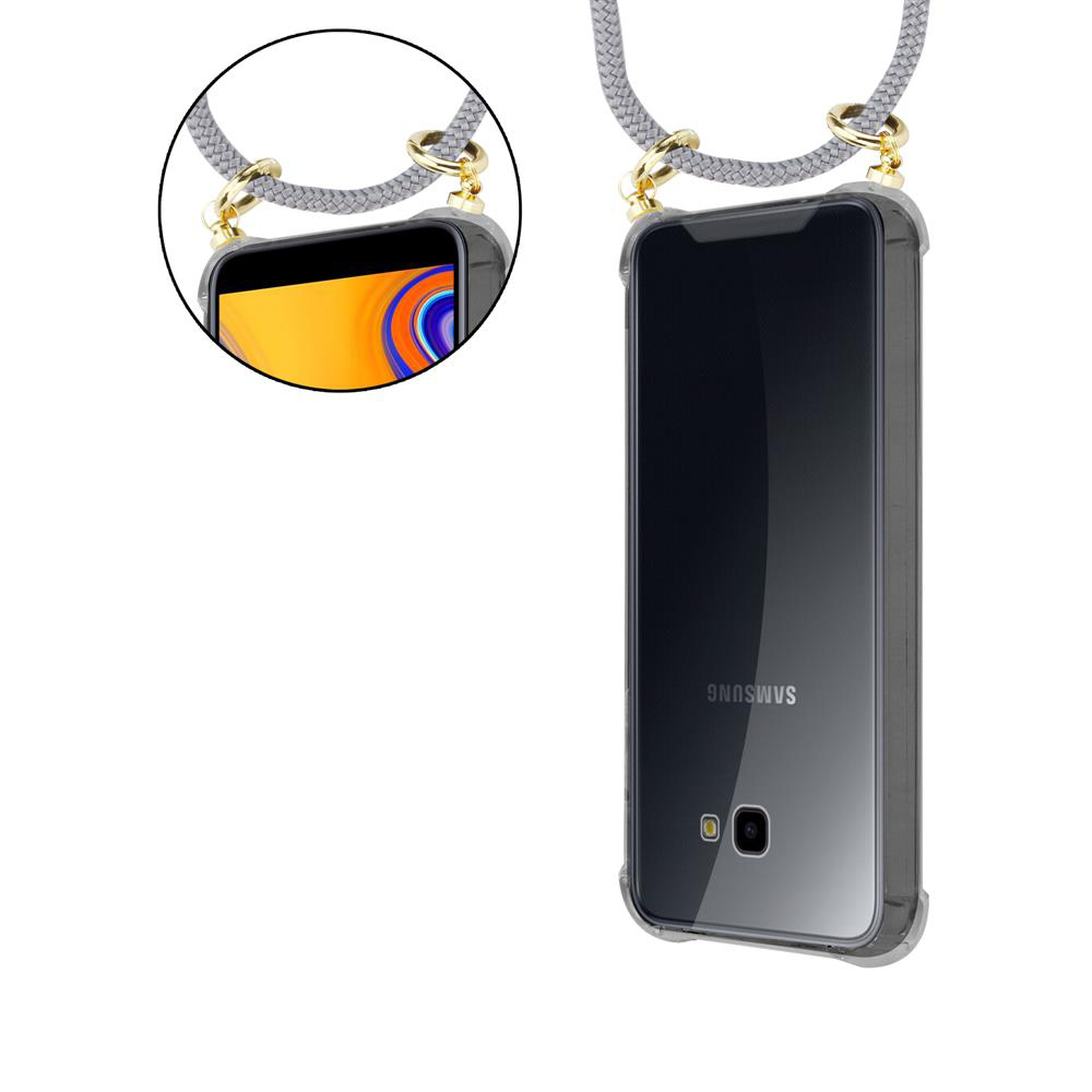 Custodia trasparente per telefono con cordino. Il telefono è un marchio Samsung. Cordino grigio con dettagli dorati.