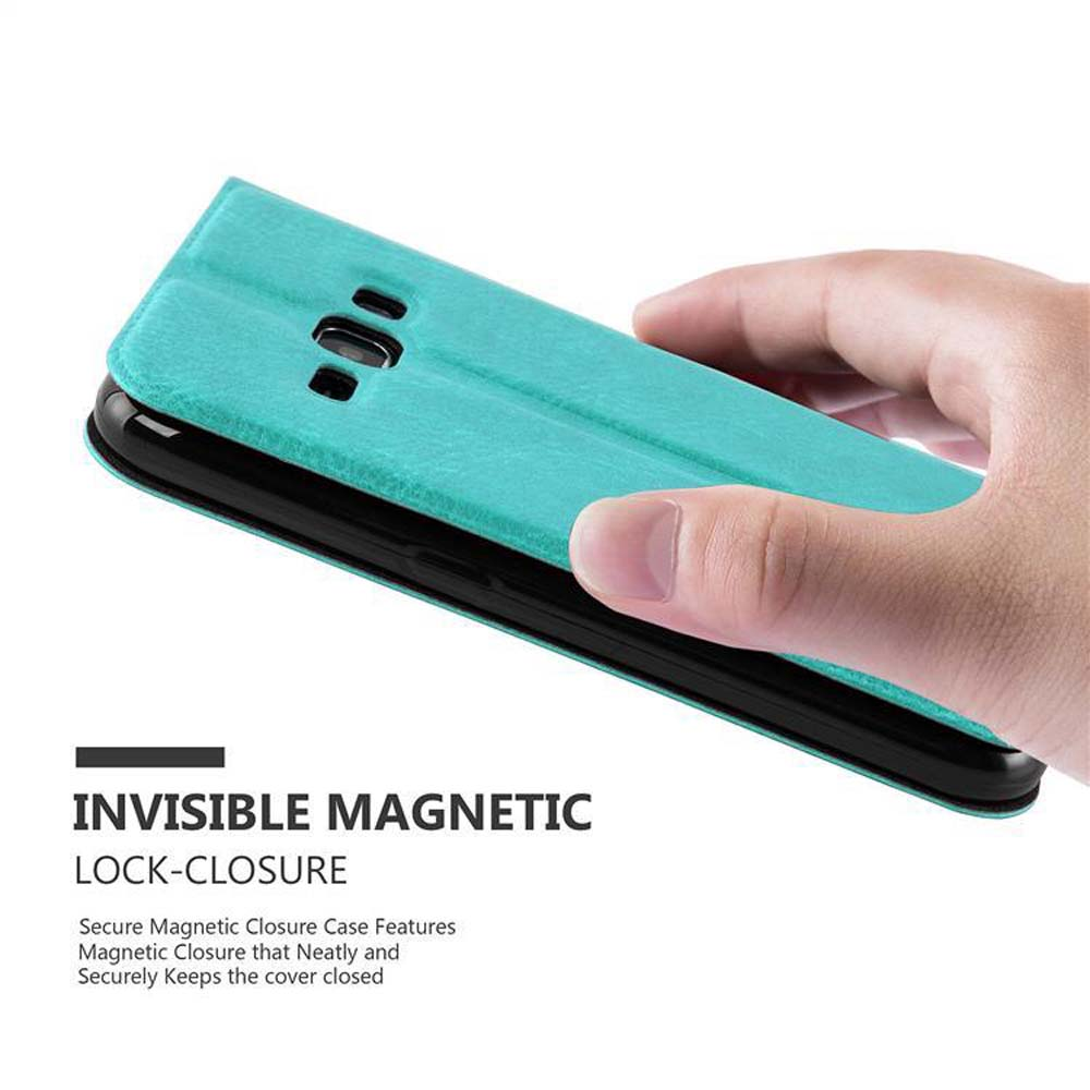 Mano che tiene una custodia per telefono verde acqua, in fase di chiusura. La custodia ha una chiusura magnetica.