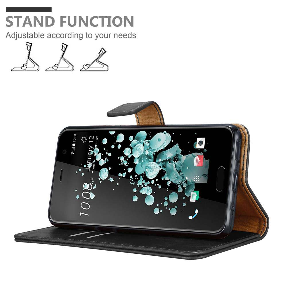 Telefon in einer Lederhülle, die als Ständer verwendet wird. Der Telefonbildschirm zeigt eine Anzeige. Text lautet 'Standfunktion'.