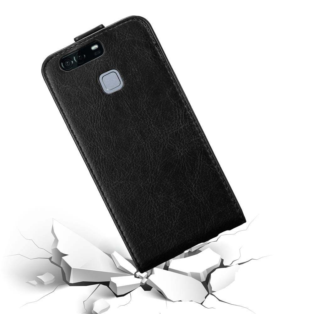 Una funda de teléfono de cuero negro, en ángulo, con un recorte para la cámara. Está sobre una superficie agrietada.