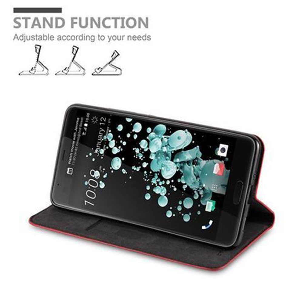 Uno smartphone su un supporto, con schermo nero, su una custodia rossa.