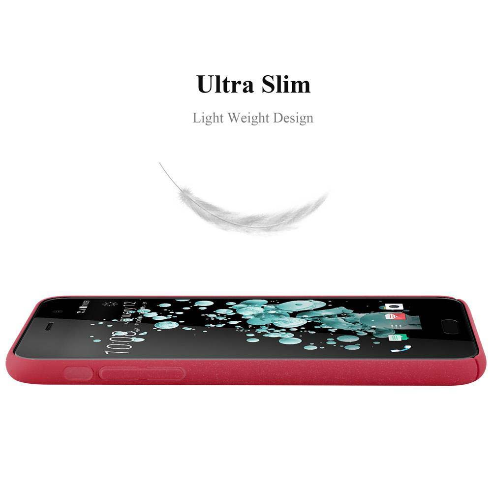 Ein rotes Telefon liegt auf einer weißen Oberfläche. Eine Feder schwebt darüber.